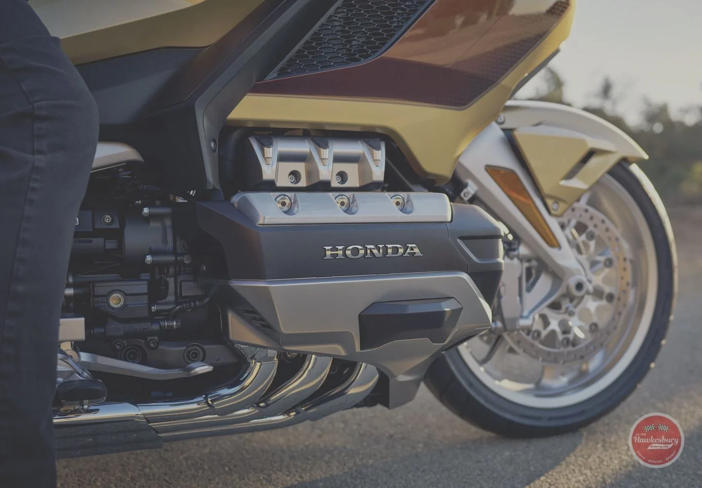 Close-up of a Honda motorcycle engine and front wheel.