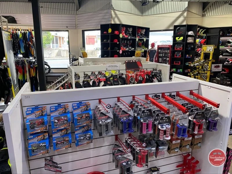 Display of bike locks and accessories inside a sporting goods store with racks of helmets and apparel in the background.