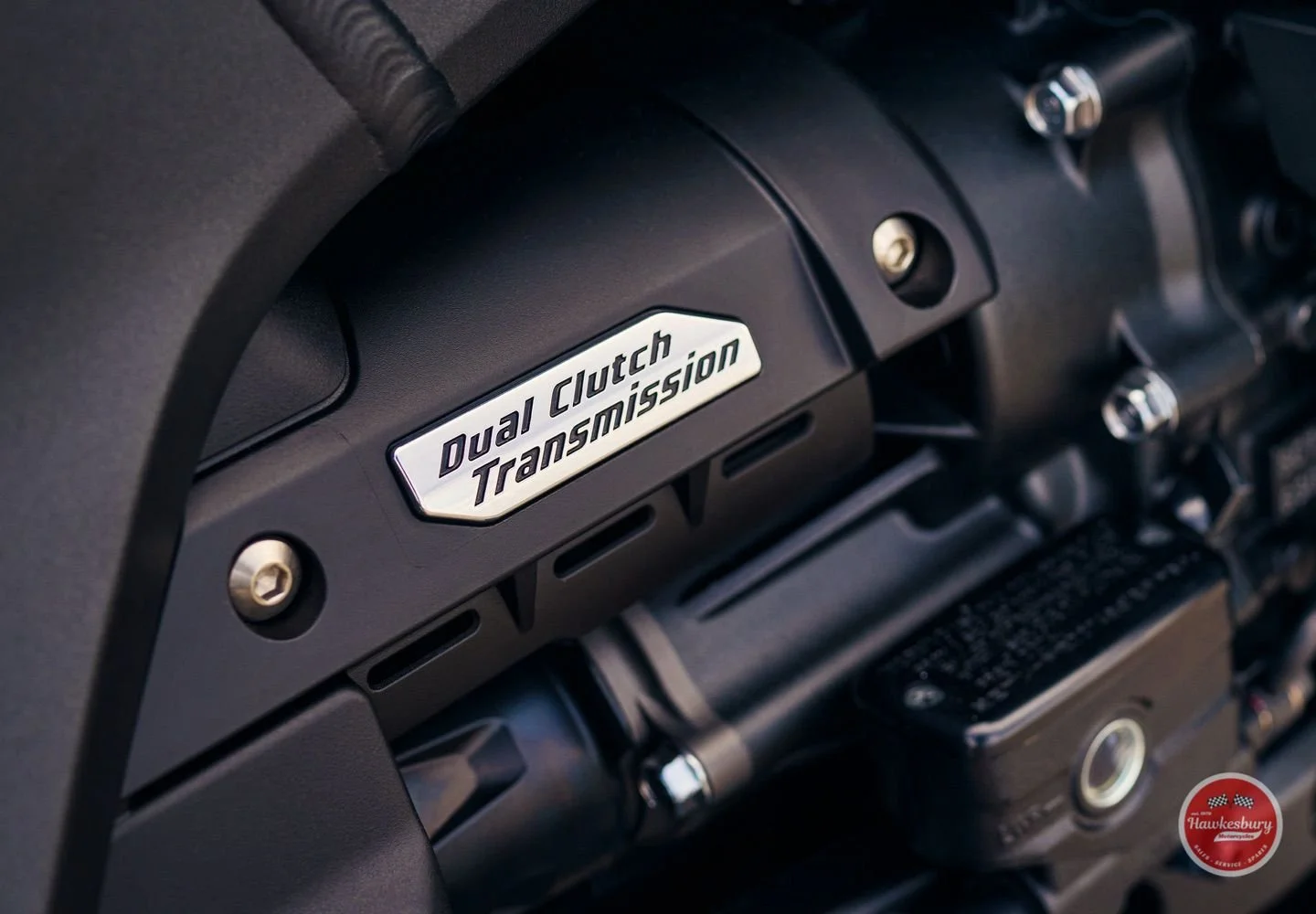 Close-up of a vehicle dashboard with a metallic badge that reads 'Dual Clutch Transmission'.