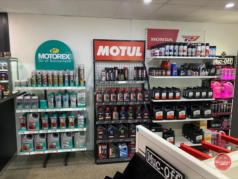 Store shelf displays motor oils and additives, including brands Motorex, Motul, and Honda.