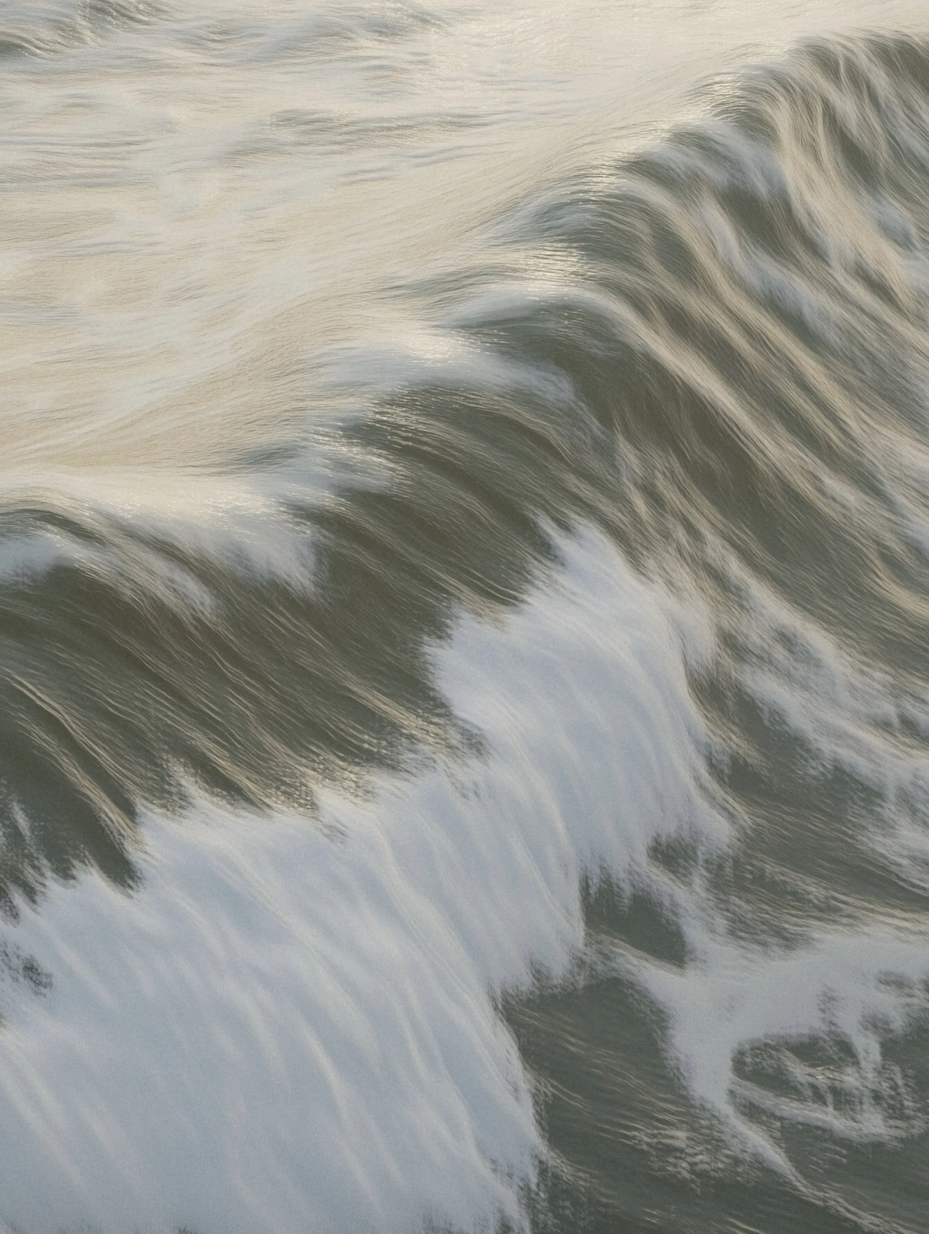 Close-up of ocean waves with foam and reflections at sunset.
