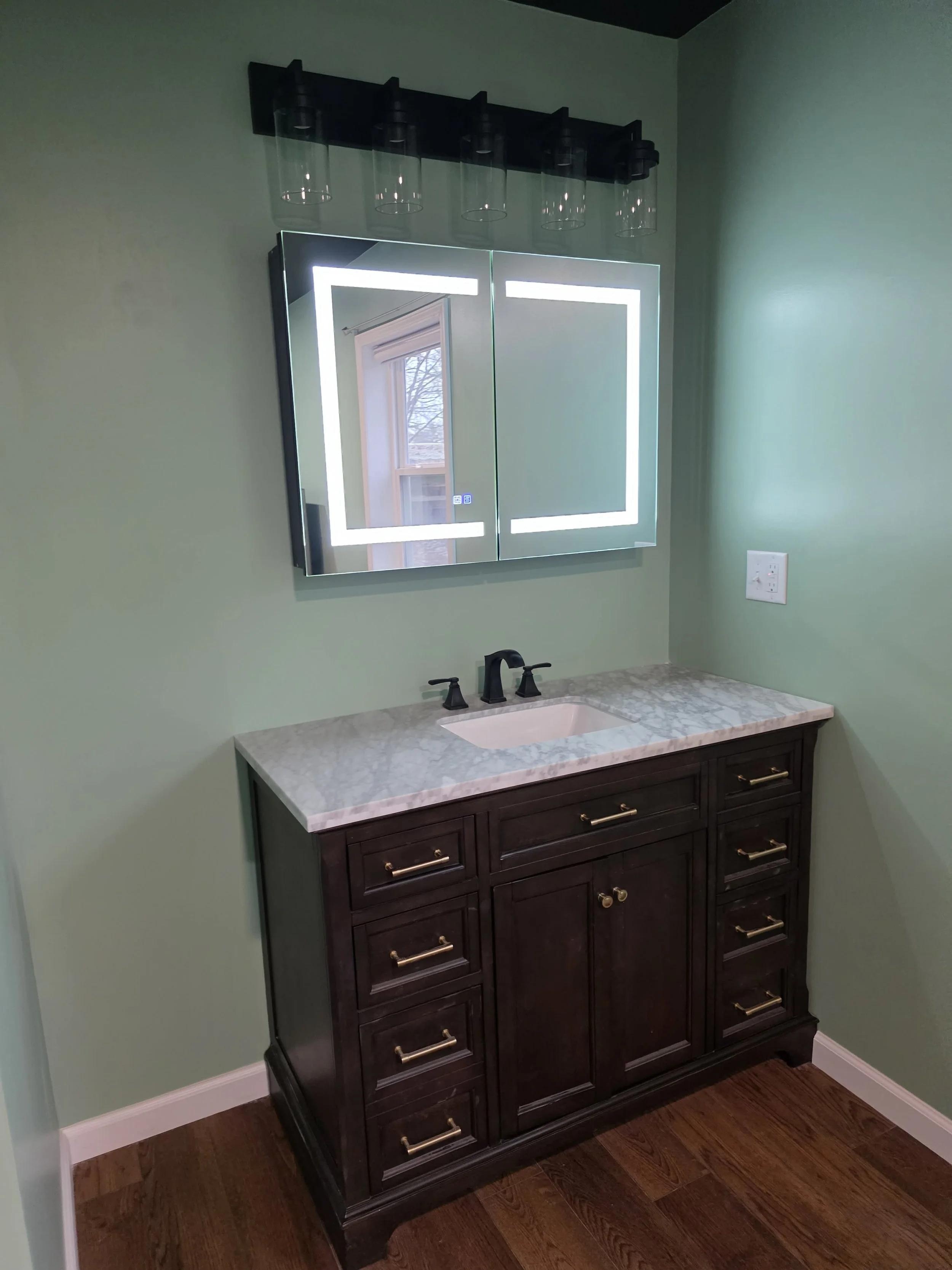 Bathroom vanity with dark wood cabinet, marble countertop, and a sink.We serve homeowners and businesses in Madison, Hanover, Scottsburg, Austin, Milton, KY, Carrollton, KY and surrounding communities throughout Jefferson County, Scott County