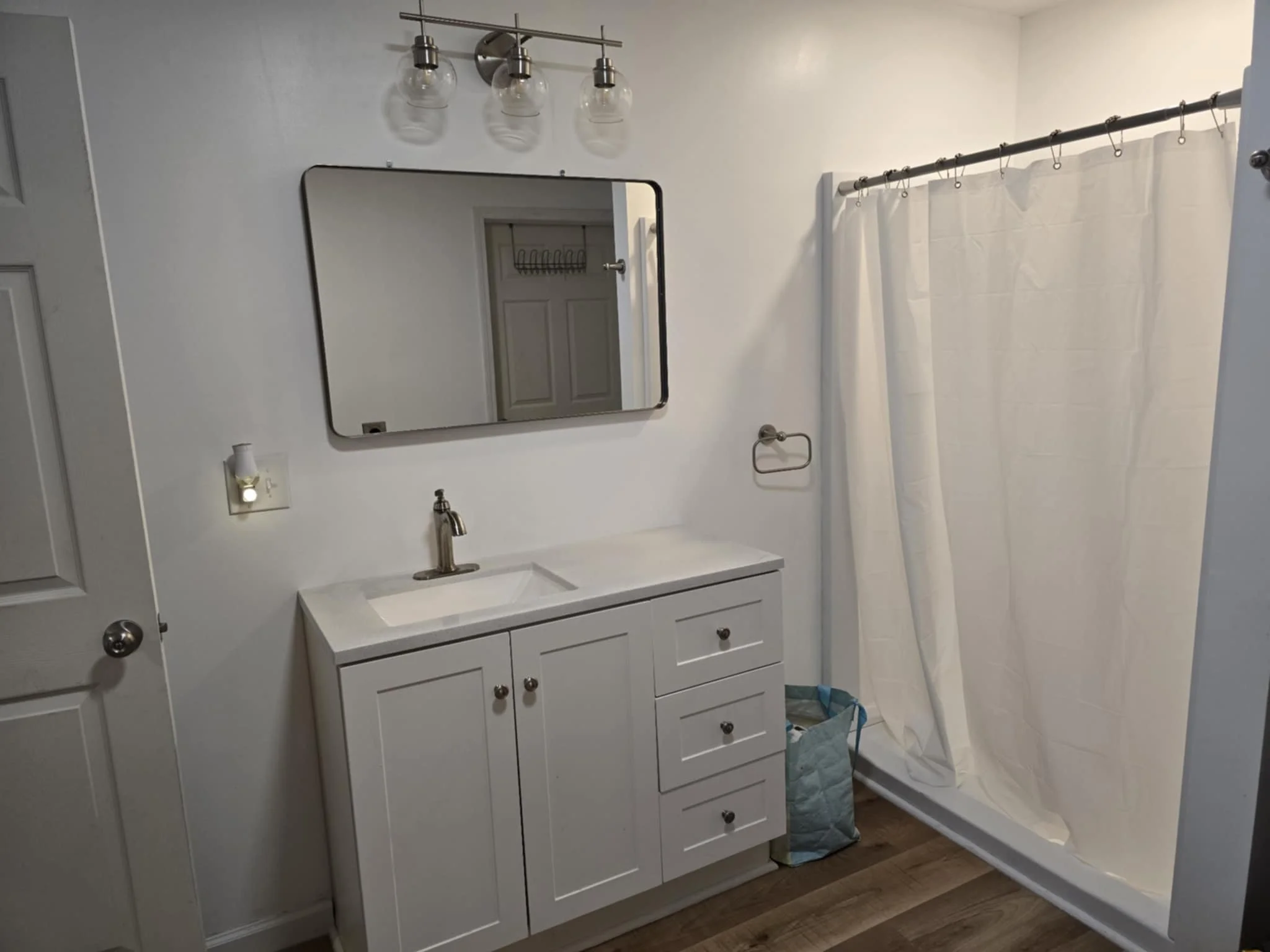 Bathroom with white vanity and sink, mirror, light fixture, towel door hook, We serve homeowners and businesses in Madison, Hanover, Scottsburg, Austin, Milton, KY, Carrollton, KY and surrounding communities throughout Jefferson County, Scott County,