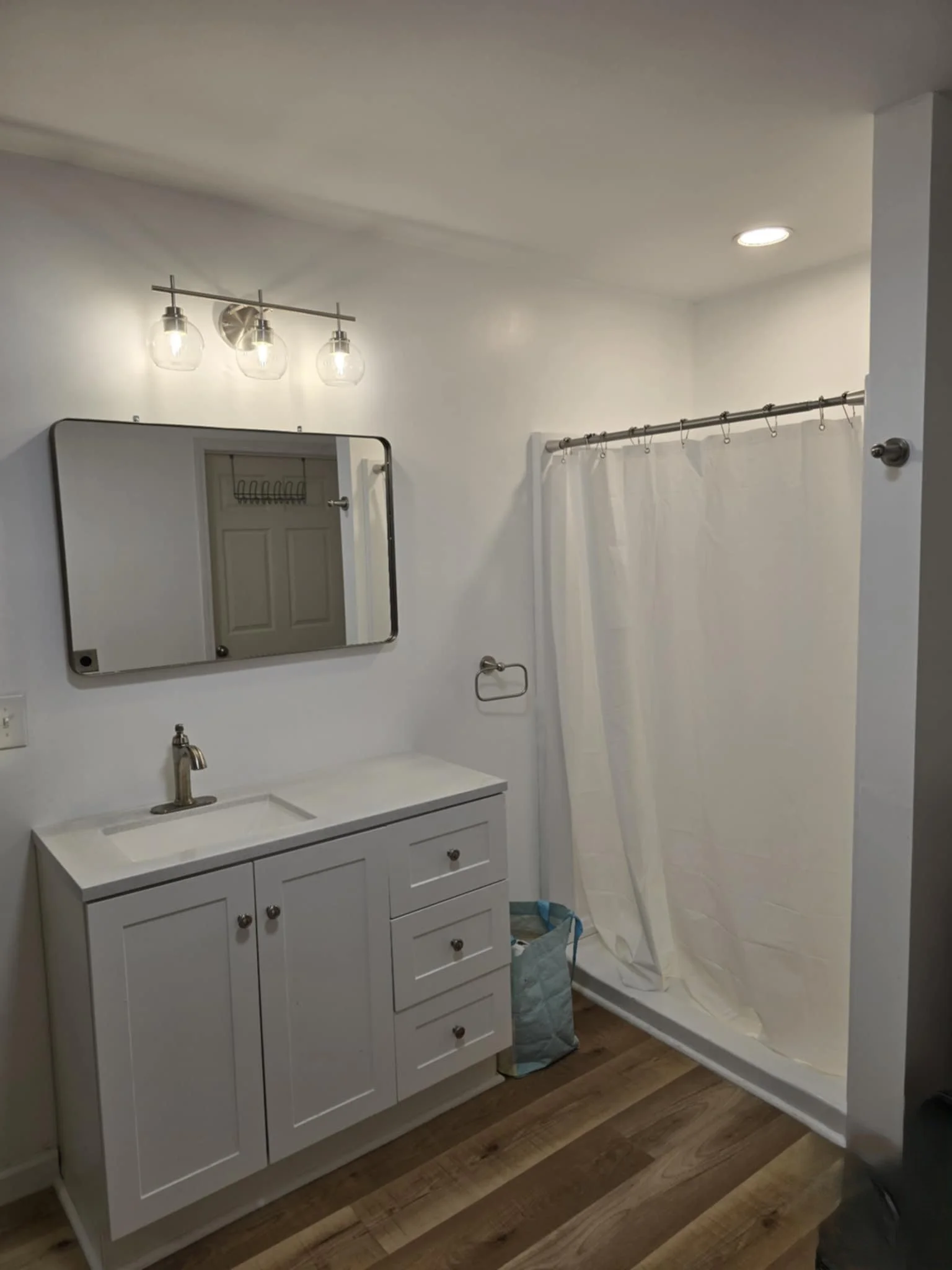 Bathroom with white vanity, mirror, three-light fixture, We serve homeowners and businesses in Madison, Hanover, Scottsburg, Austin, Milton, KY, Carrollton, KY and surrounding communities throughout Jefferson County, Scott County, Clark County, 
