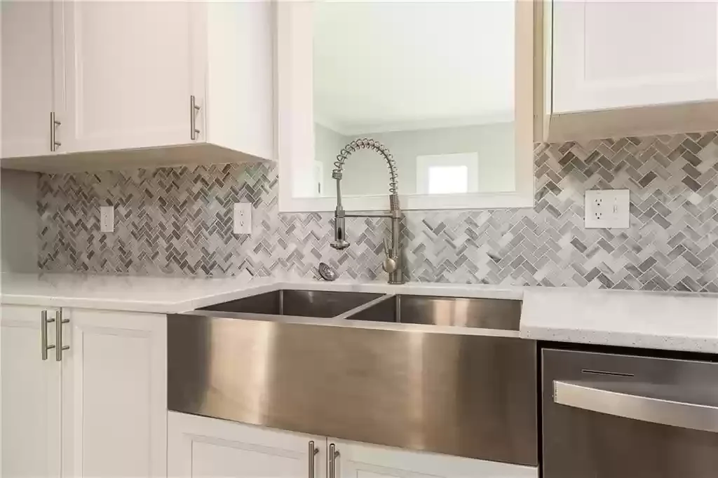 Modern kitchen with white cabinets, a stainless steel farmhouse sink, a patterned gray tile backsplash, We serve homeowners and businesses in Madison, Hanover, Scottsburg, Austin, Milton, KY, Carrollton, KY and surrounding communities