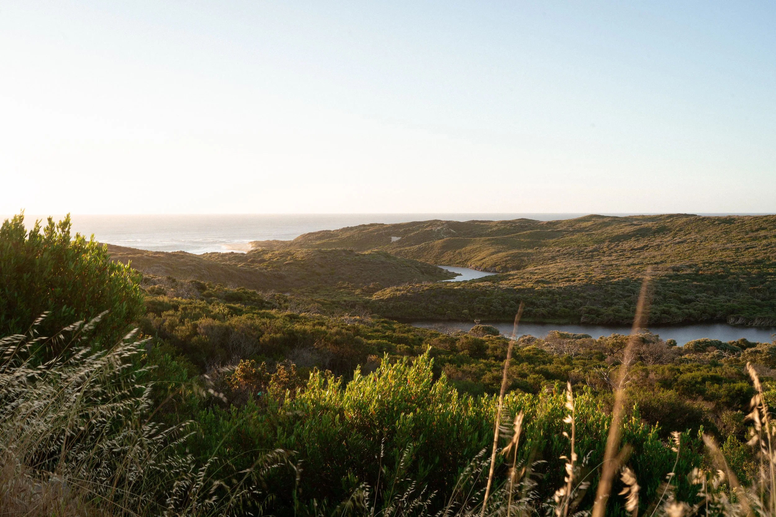 Aerial view of the Margaret River Mouth showing the river winding through the landscape as it meets the ocean, highlighting the natural meeting point of land and sea often featured in Margaret River maternity photography sessions.