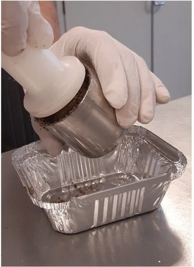 Persoon die een droogijs- of rokenapparaat in een aluminium bak plaatst.