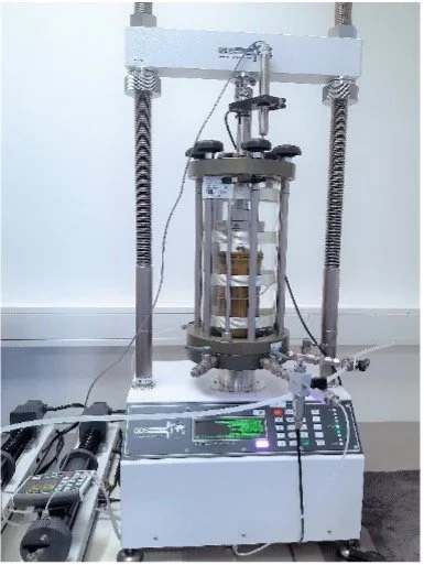 Een laboratoriumapparaat met een cirkelvormige structuur en verschillende draden en controlepanelen.