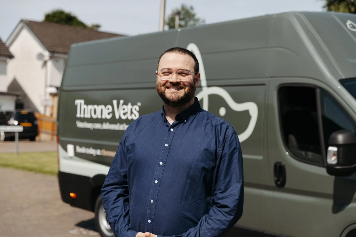 Murray, business director t at Throne vets, smiling in front of Throne Vets Mobile Clinic Vehicle.