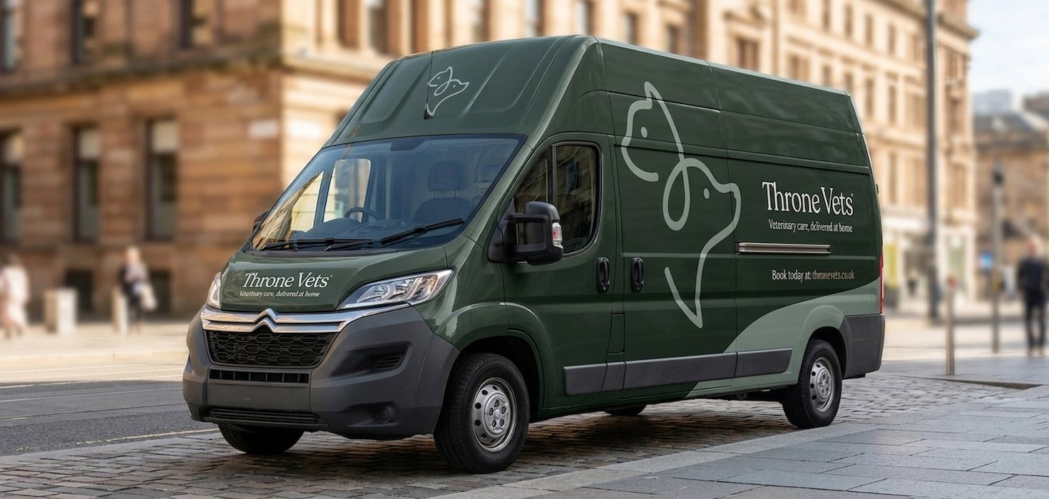 The mobile clinic for Throne vets, which is a green delivery van with 'Throne Vets' branding and a Throne vets logo parked on a Glasgow city street with historic buildings in the background.