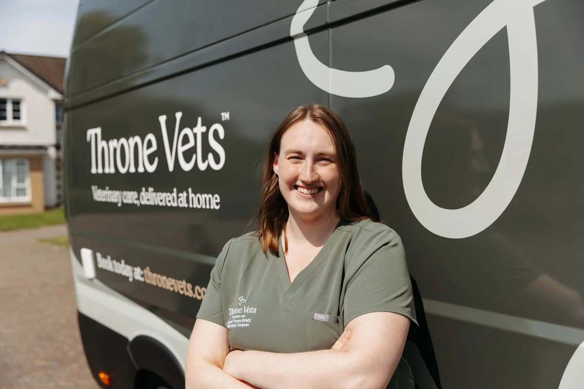 Rachel, head vet at Throne vets, smiling wearing green scrubs standing in front of Throne Vets Mobile Clinic Vehicle.