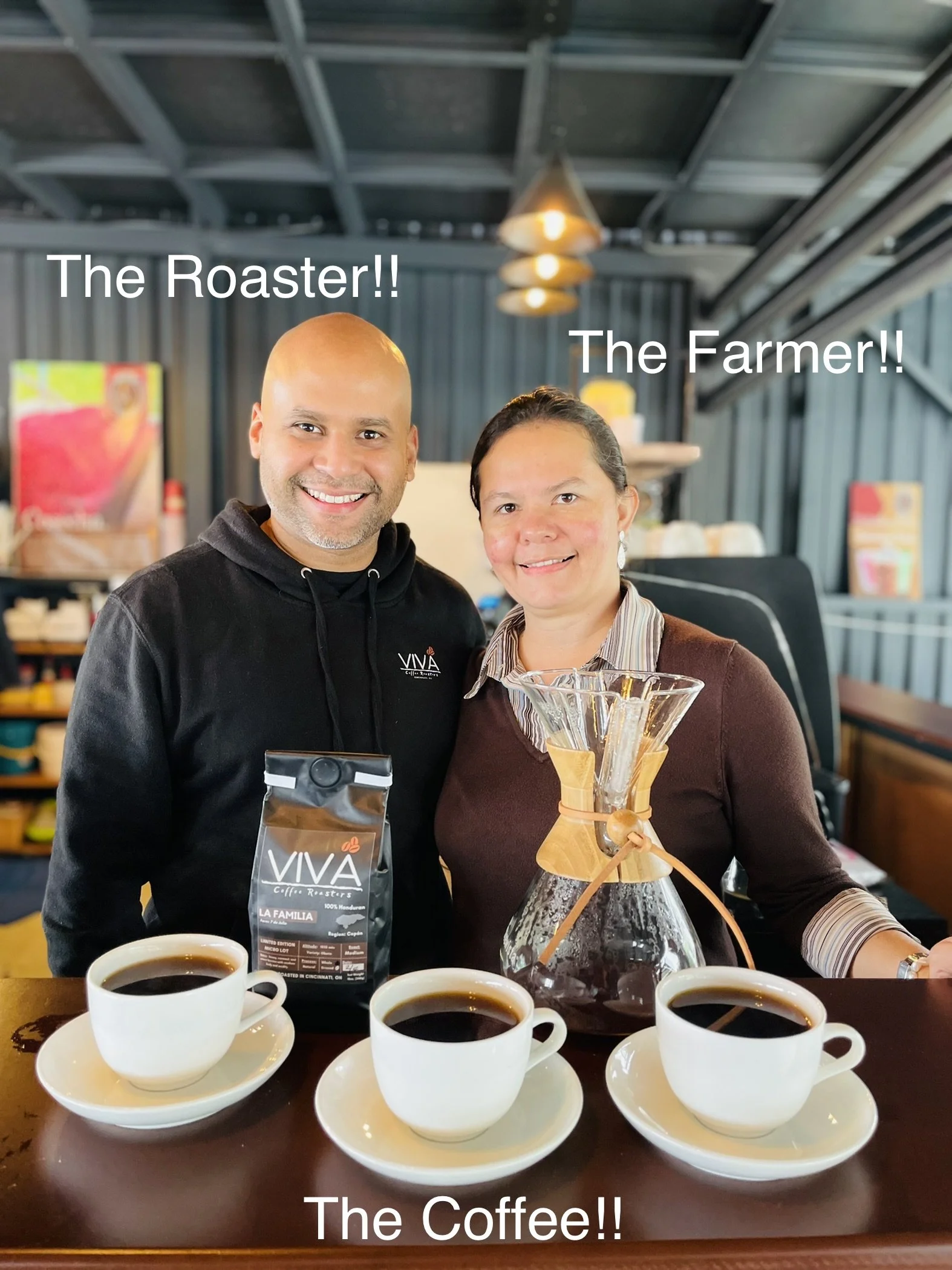 Two people, a man and a woman, smiling behind a counter with three cups of coffee, a coffee brewing setup, and a bag of coffee beans. The man is labeled as "The Roaster!!" and the woman as "The Farmer!!" in white text.
