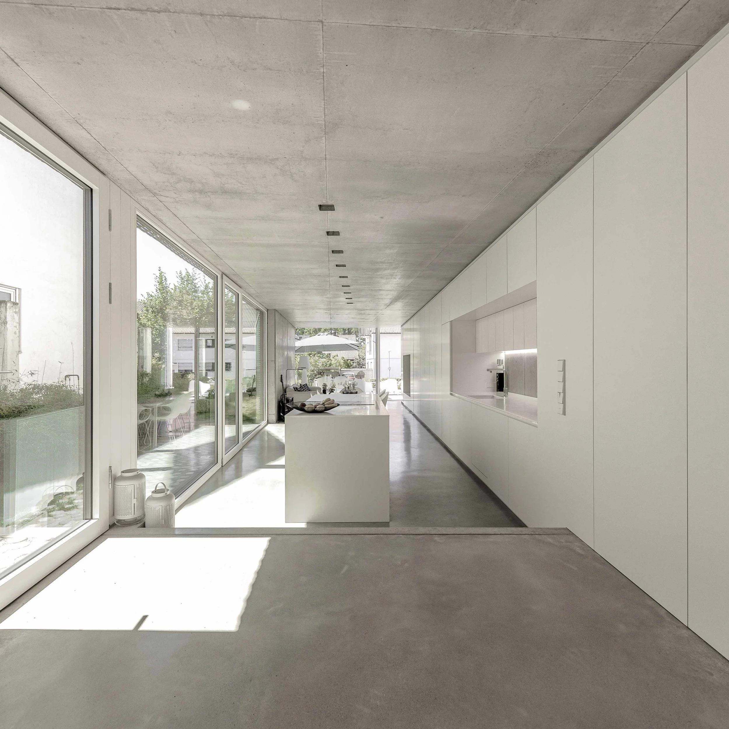 Innenansicht eines modernen, minimalistischen Hauses mit viel Tageslicht, freier Sicht und weißen Wänden.