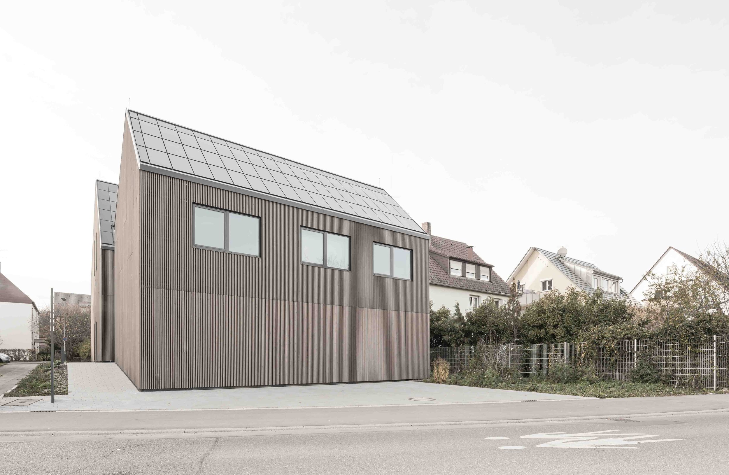 polizeiposten LE - Modernes Haus mit Holzfassade und Solardach in einer Wohngegend.