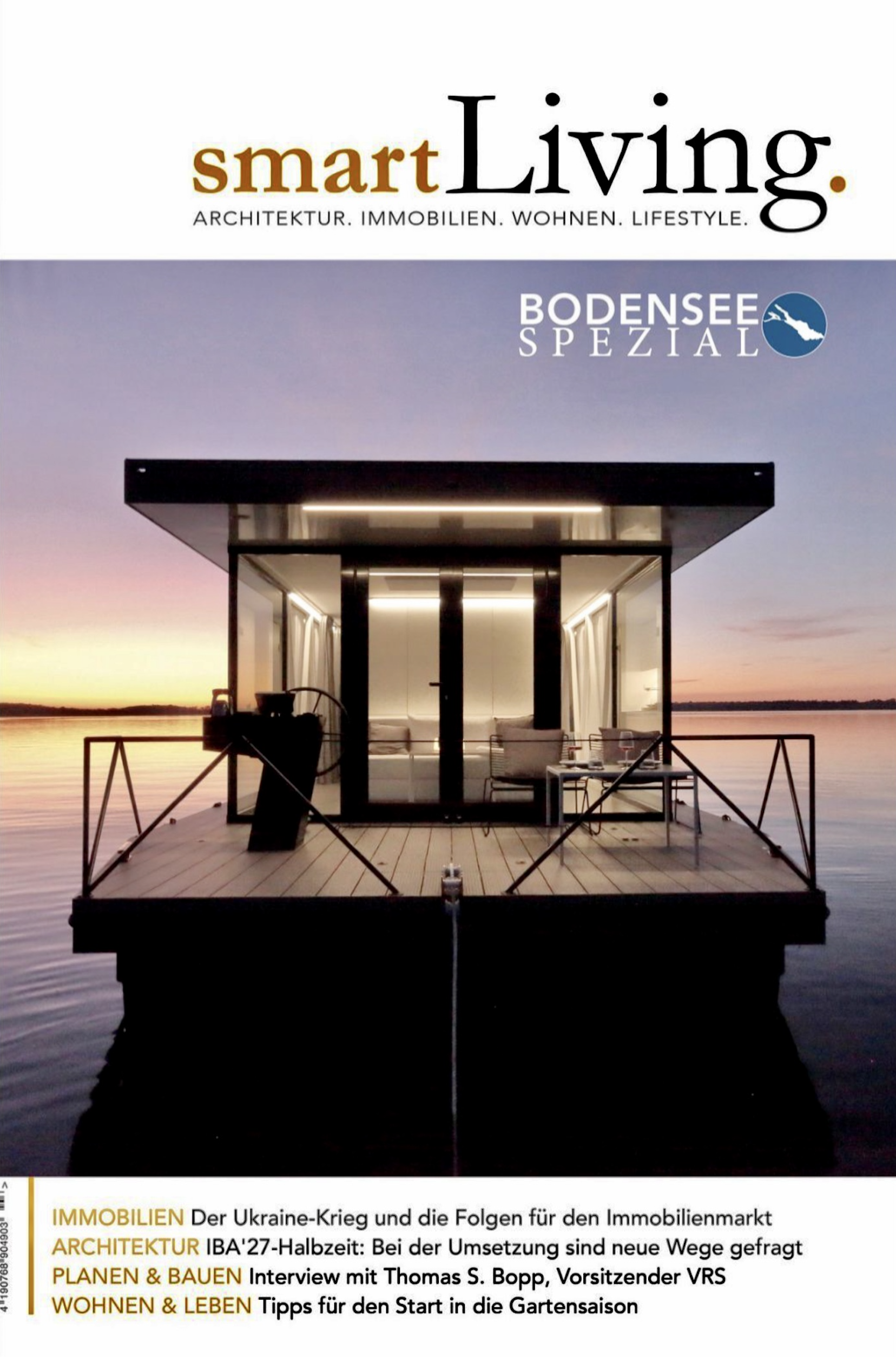 Ein modernes Haus auf einem Steg über einem See bei Sonnenuntergang, mit gehobener Einrichtung im Innenraum und einem Wasserblick im Hintergrund.