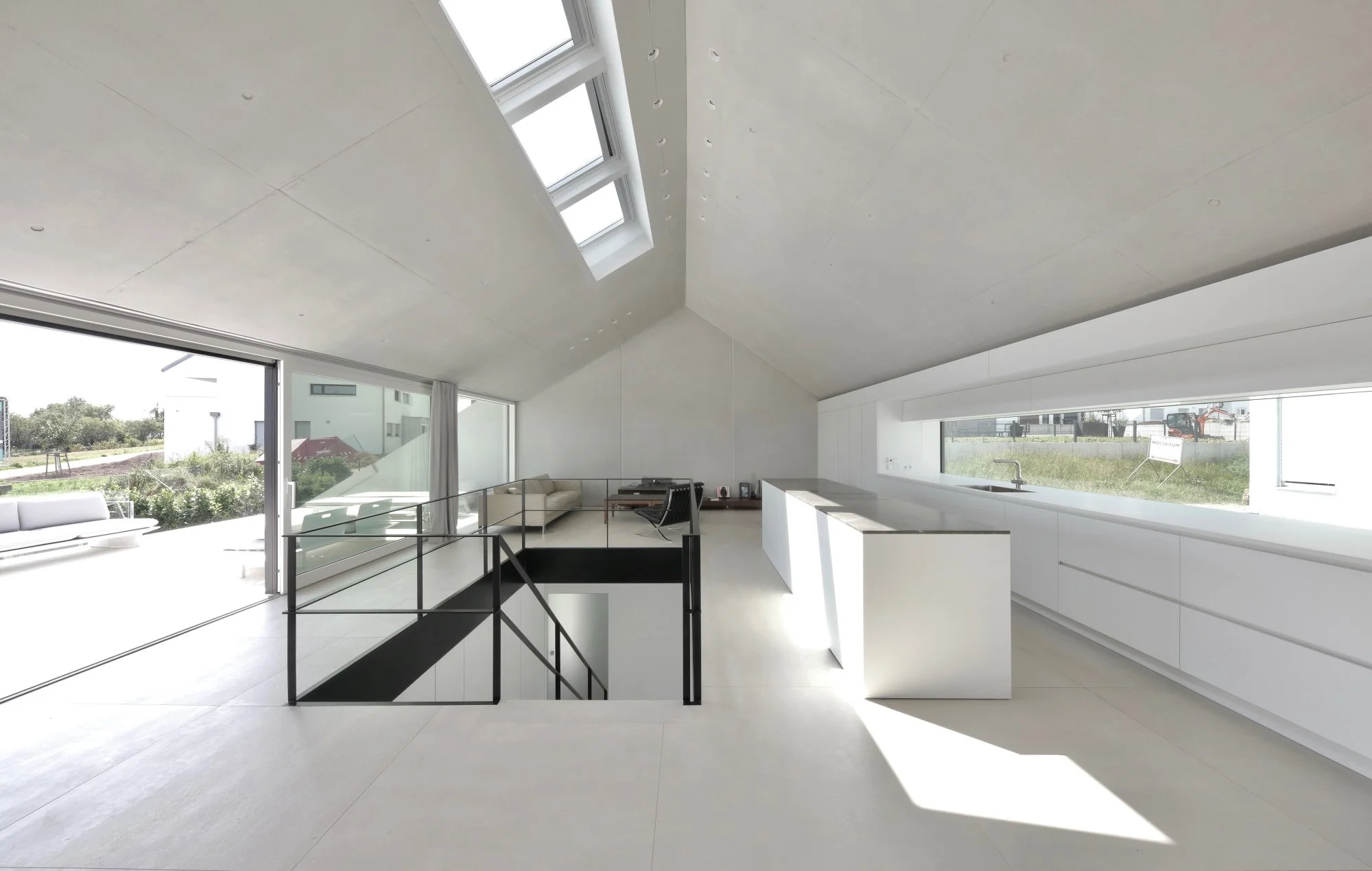 haus CC - Moderner, heller Innenraum mit großem Fenster und skandinavischer Einrichtung, offene Küche und Wohnbereich, minimalistisch gestaltet.