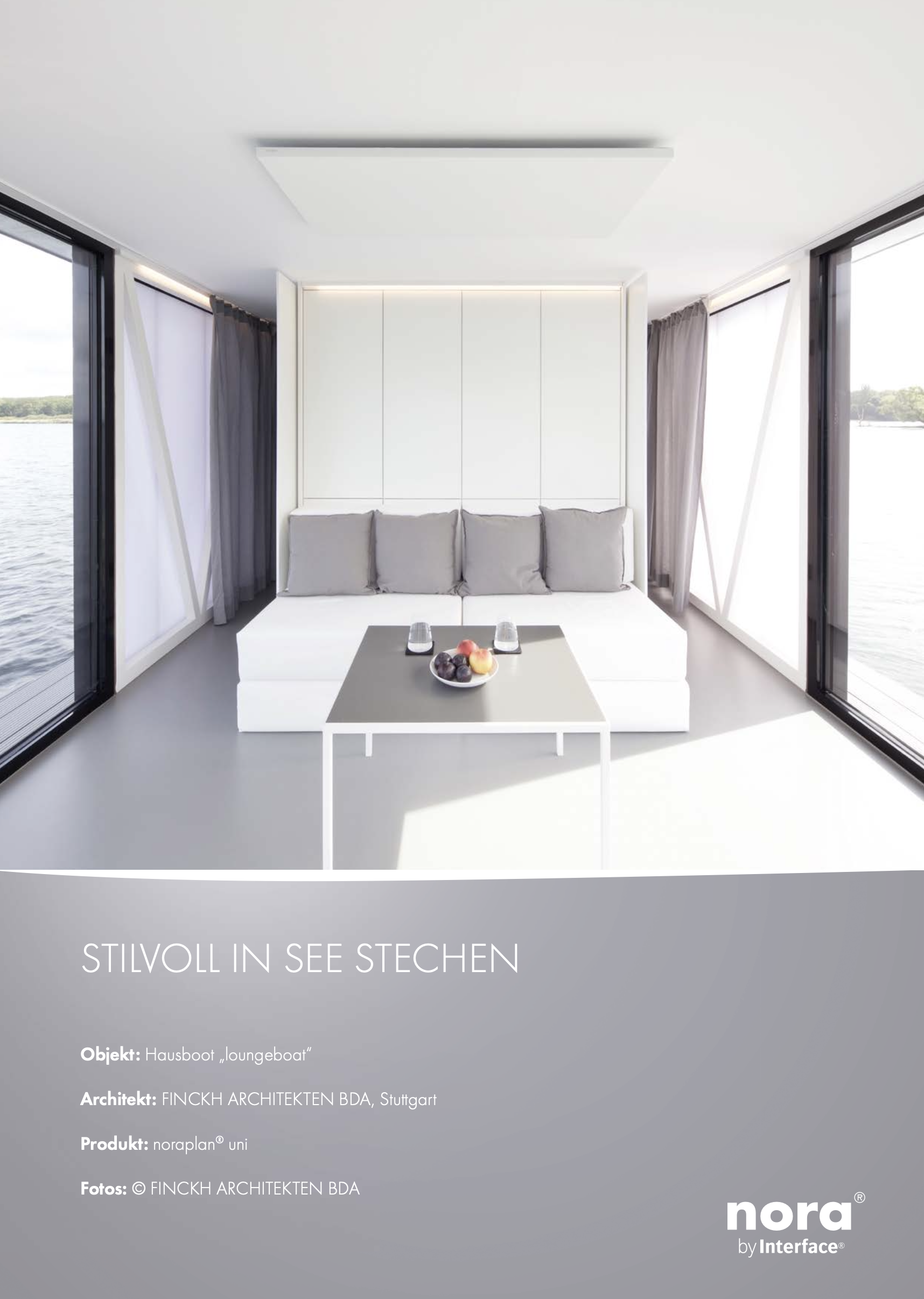 Ein weißer Lounge-Boot im Innenraum mit großen Fenstern, Blick auf den See, helles modernes Design, Kerzen auf einem Tisch, Text über Nachhaltigkeit und Architektur auf Deutsch