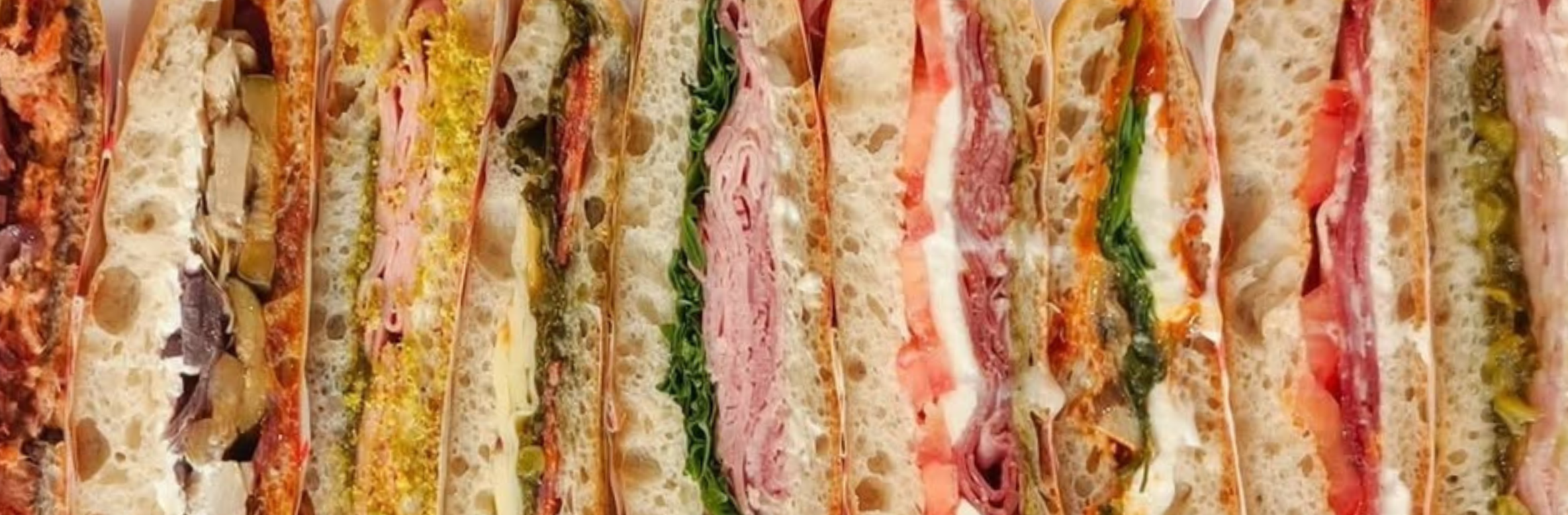 Range de sandwiches variés avec différentes garnitures.