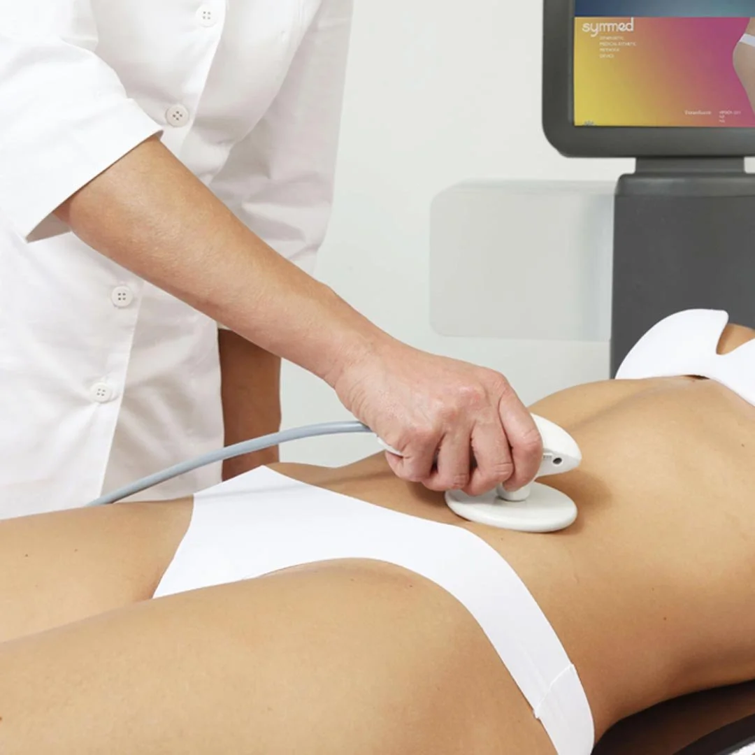 Medical professional uses ultrasound device on patient lying on examination table in clinical setting.