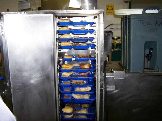 This is the 'Hot Box.' General population inmates prepare our food on blue trays and then place them in these boxes to keep them warm until the guards can feed us.