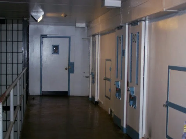 These doors have plexiglass on them. This is F-Pod or what we like to call 'the dungeon.' The paint scheme is no longer blue, but a dark green, which makes it all the more oppressive feeling. These cells house inmates who have, for some reason or ano