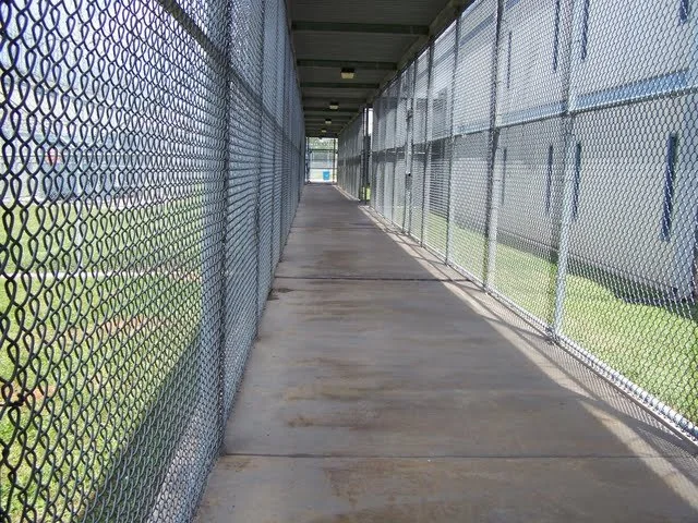 This sidewalk leads to a back door of the visitation area that Death Row inmates enter from. The building on the right side is 11 building or Pre-Hearing Detention (PHD). PHD is used to house inmates in general population if they've gotten into a fig