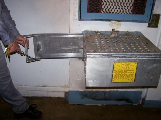 This is the 'management cell.' The cell is primarily used for the most aggressive inmates. Those who have 'chunked' (i.e. throw feces or urine an inmate or officer) or who are being disciplined. The purpose of the box is so that the guards can give y