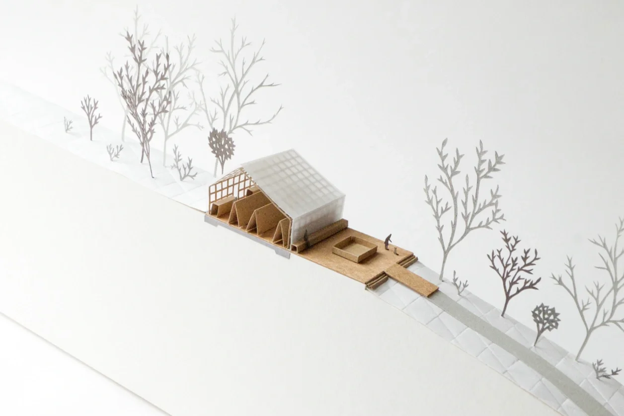 Cross section model through a building and terrace and the tree lined landscape in front and behind it