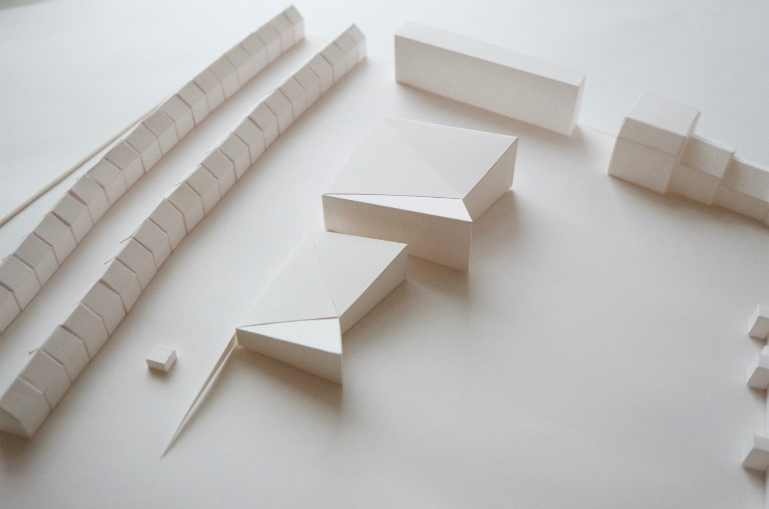 Contemporary white paper massing models with a row of terraced houses beyond