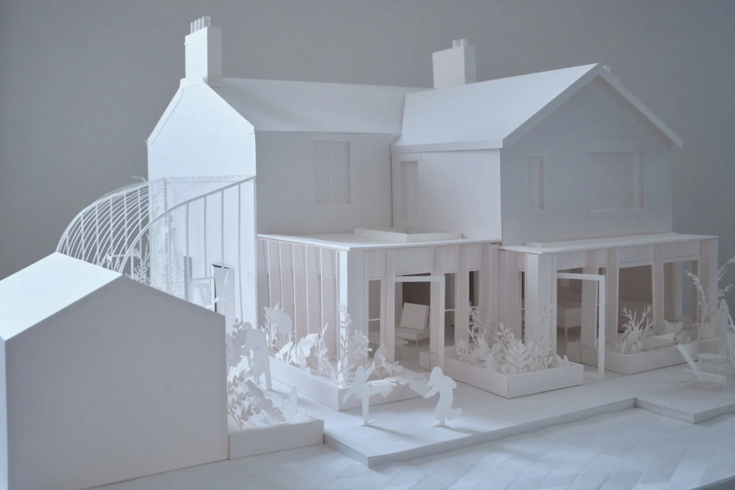 House with single storey addition modelled in white paper, complete with intricately detailed flower beds