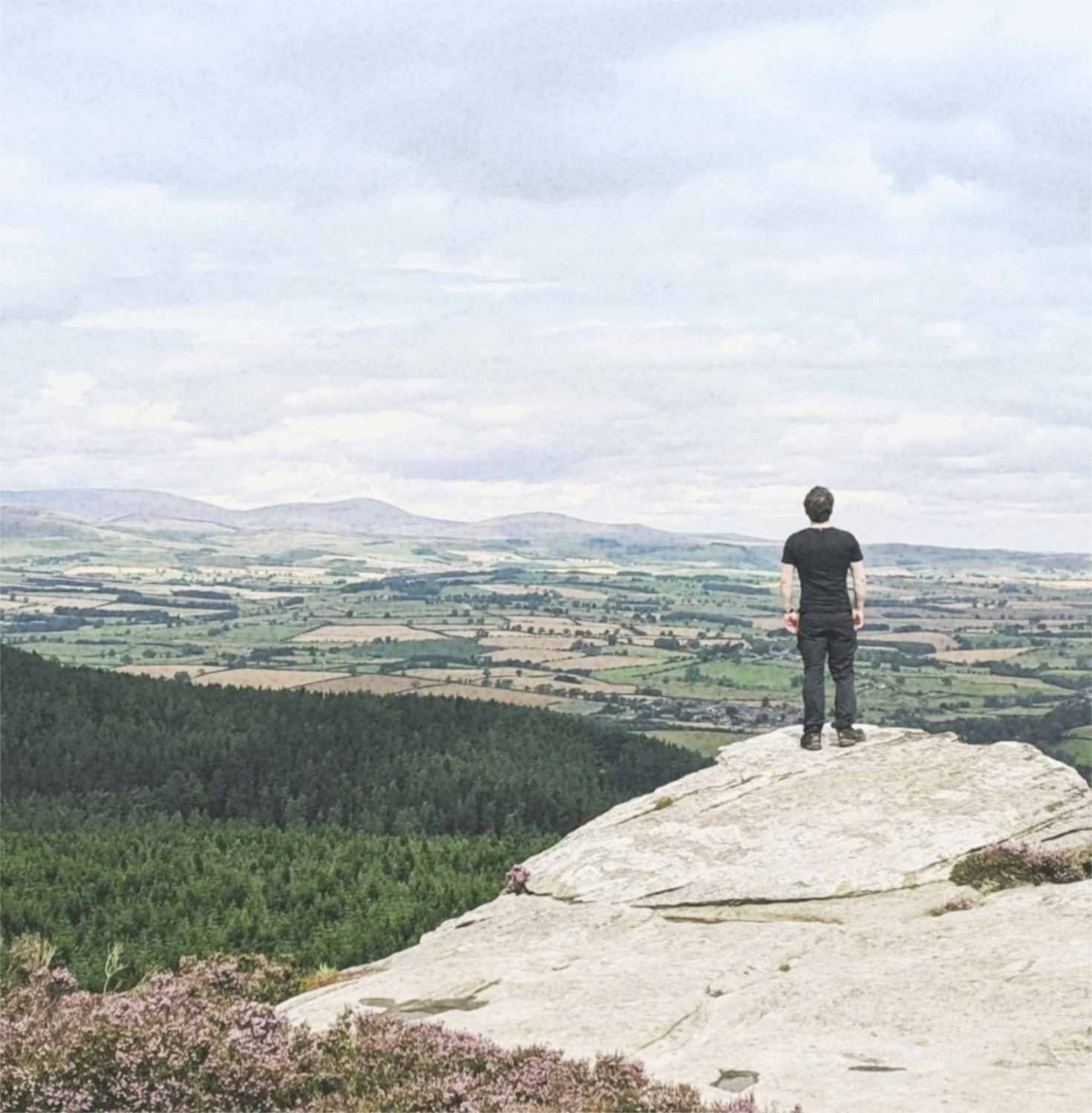 Harrison stood on a rock looking out over rolling countryside
