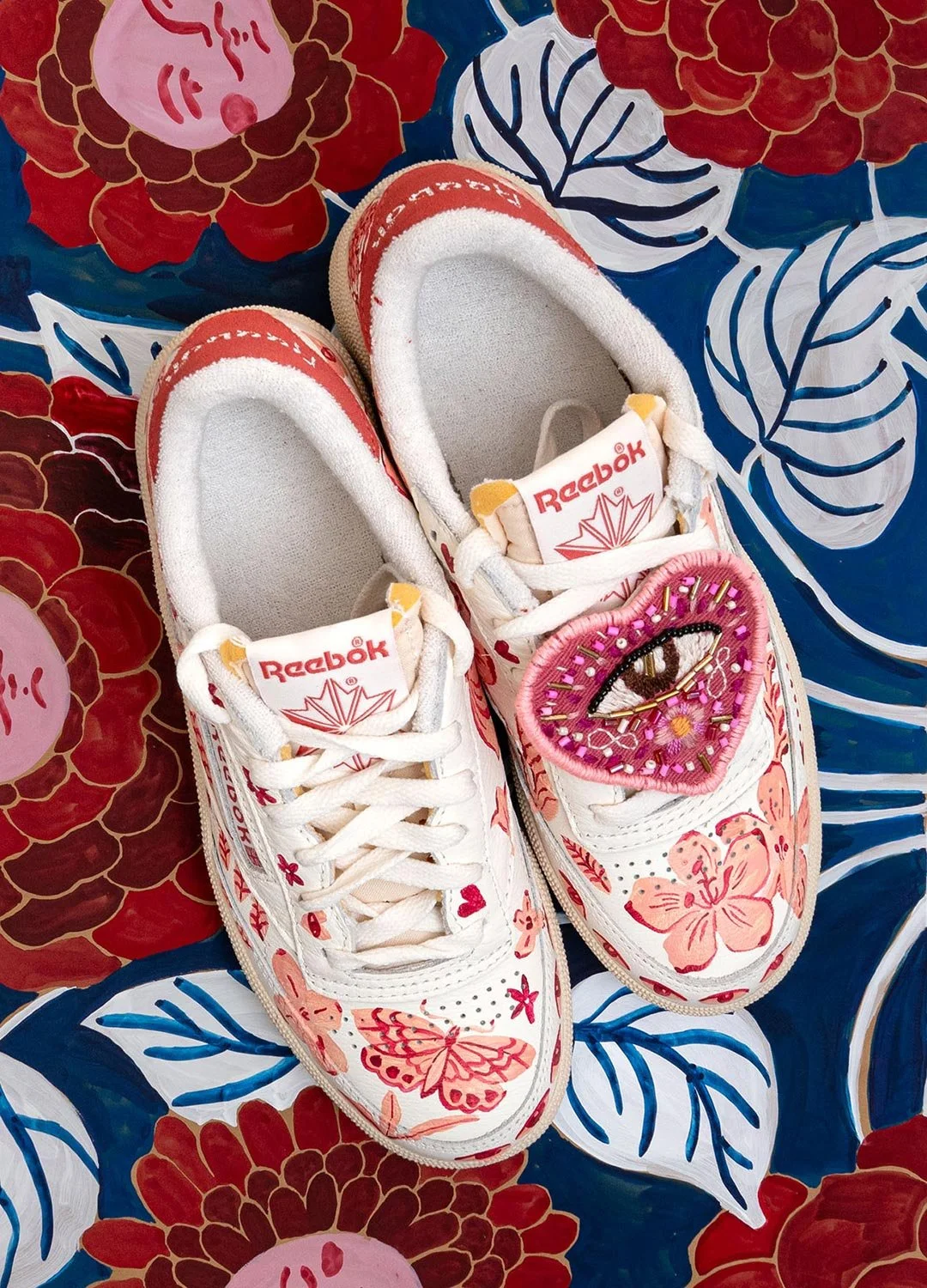 embroidered reebok sneakers sitting on a floral background