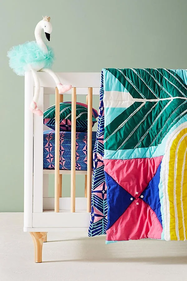 Colorful quilt laid over baby crib