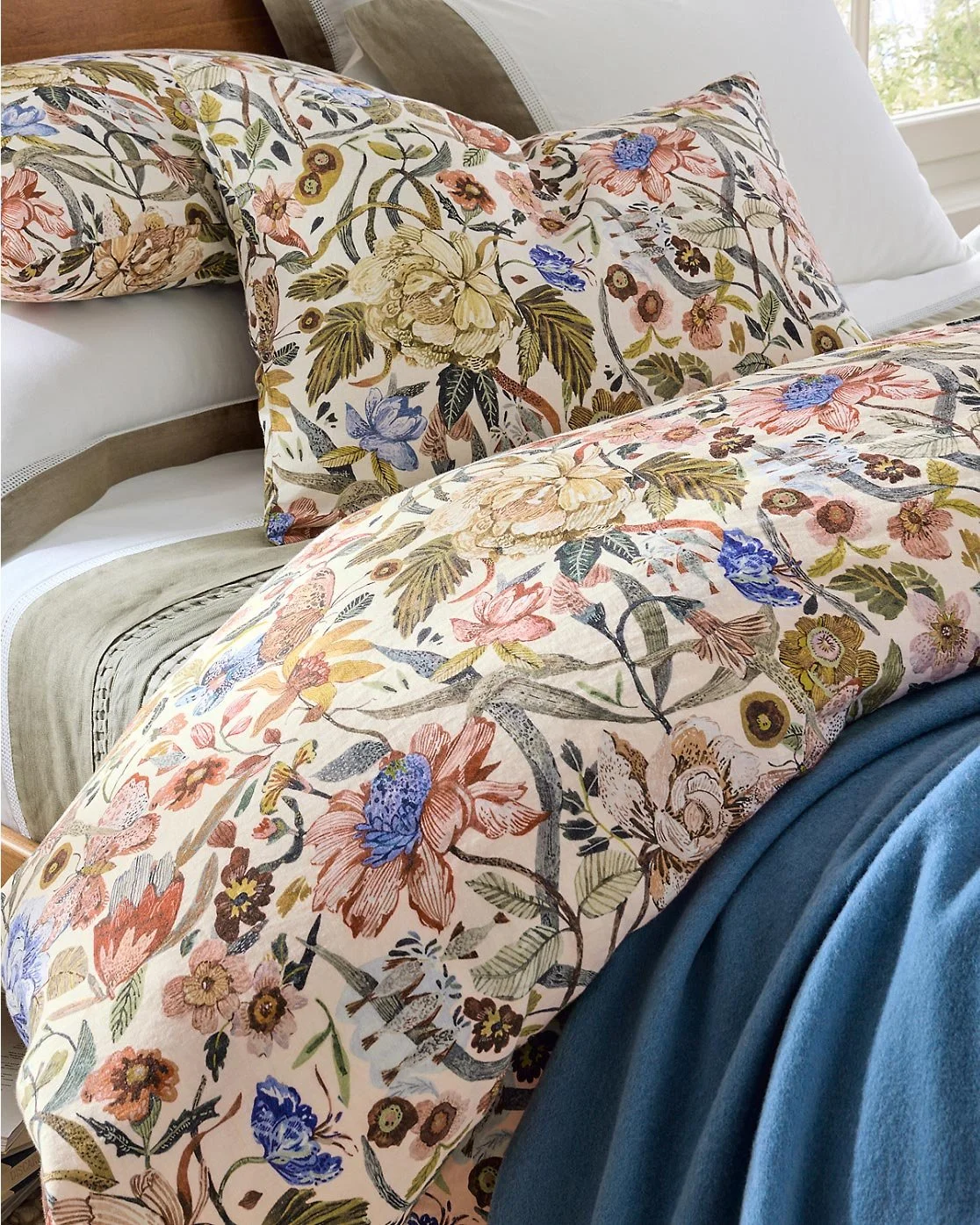 floral comforter and sham with blue blanket and beige sheets