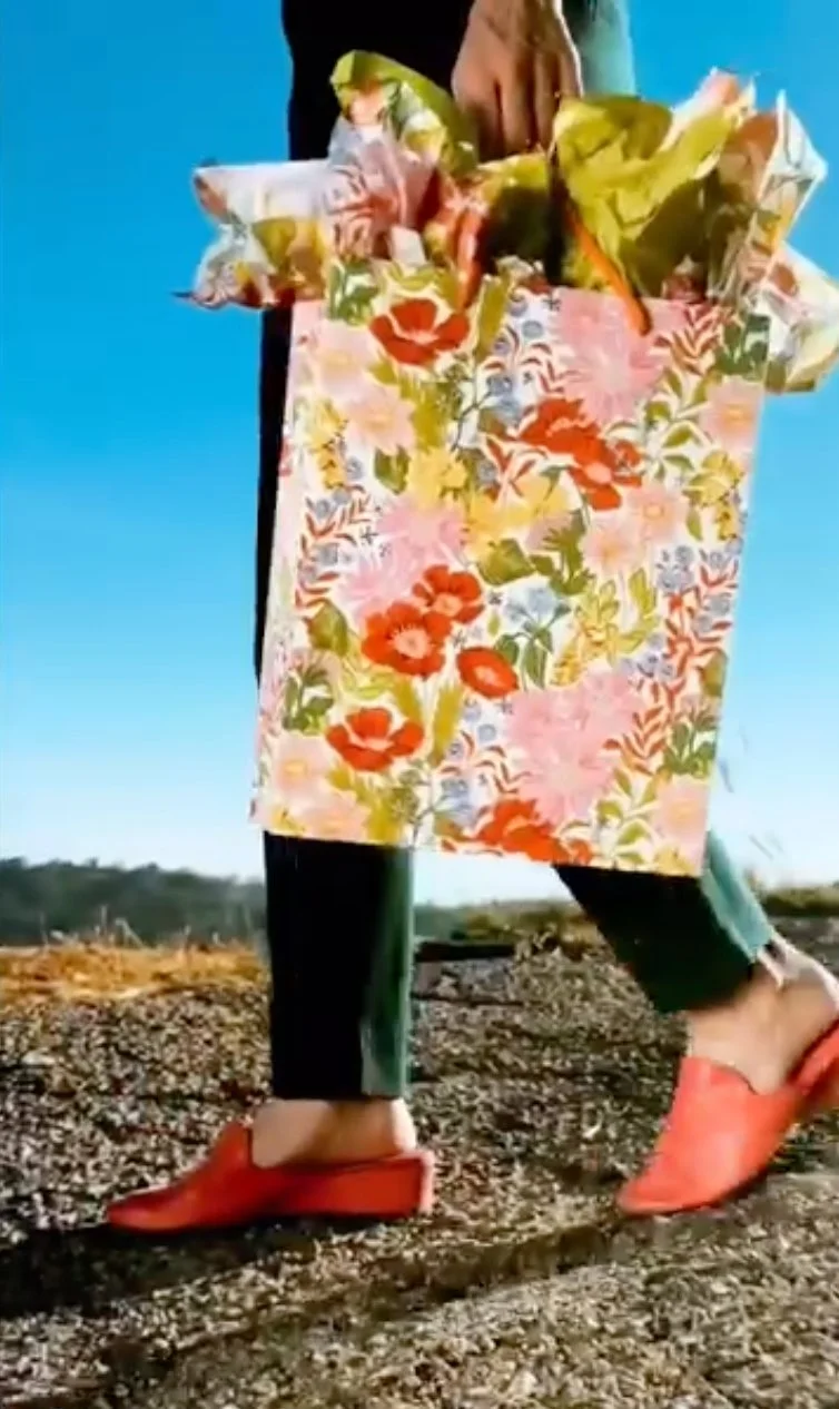 Person carrying floral gift bag