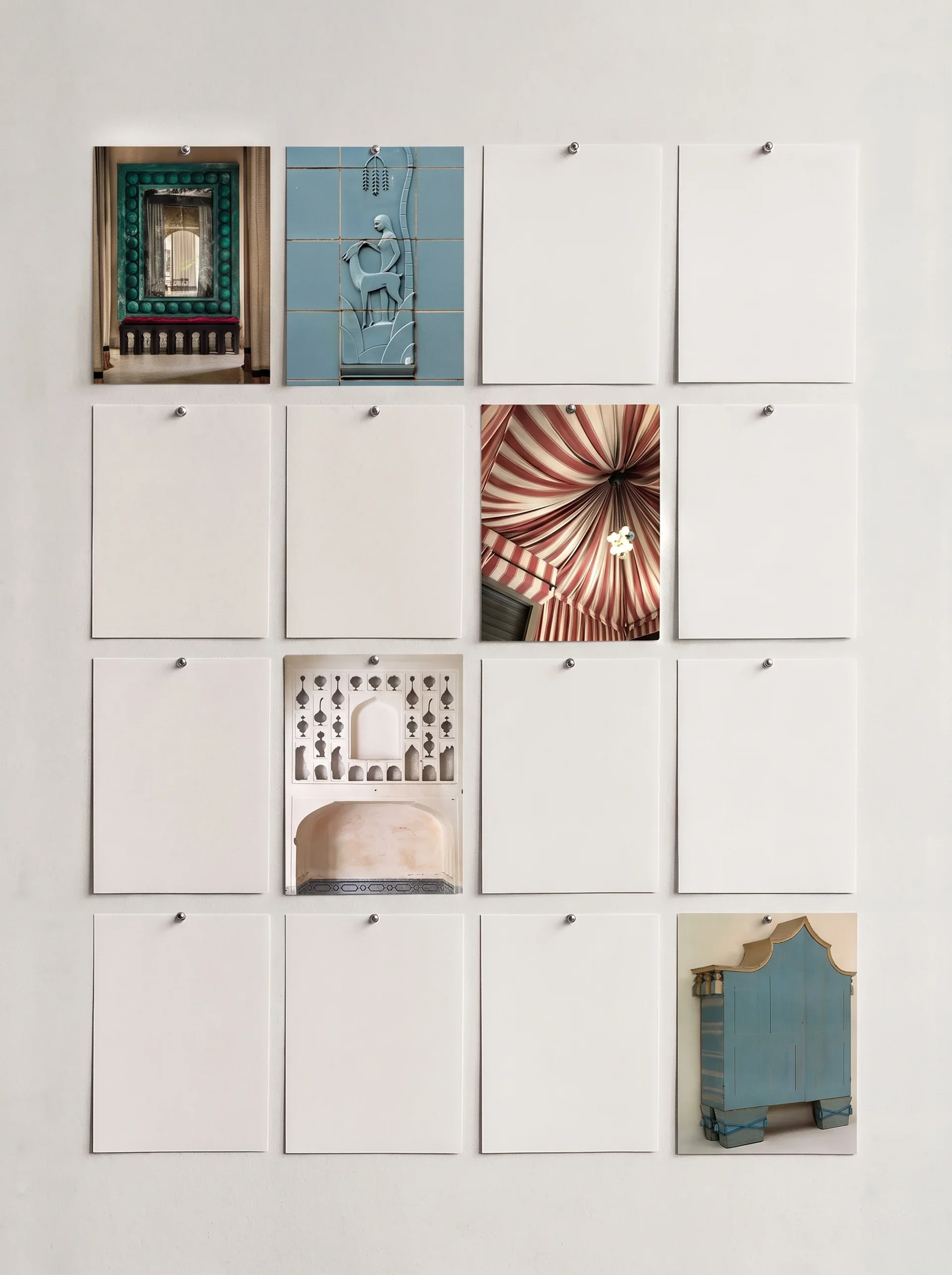 A wall display with arranged photographs of architectural and decorative elements, including a mirror with a green frame, a blue tile mosaic depicting a woman and a camel, an ornate blue cabinet, and other architectural details.