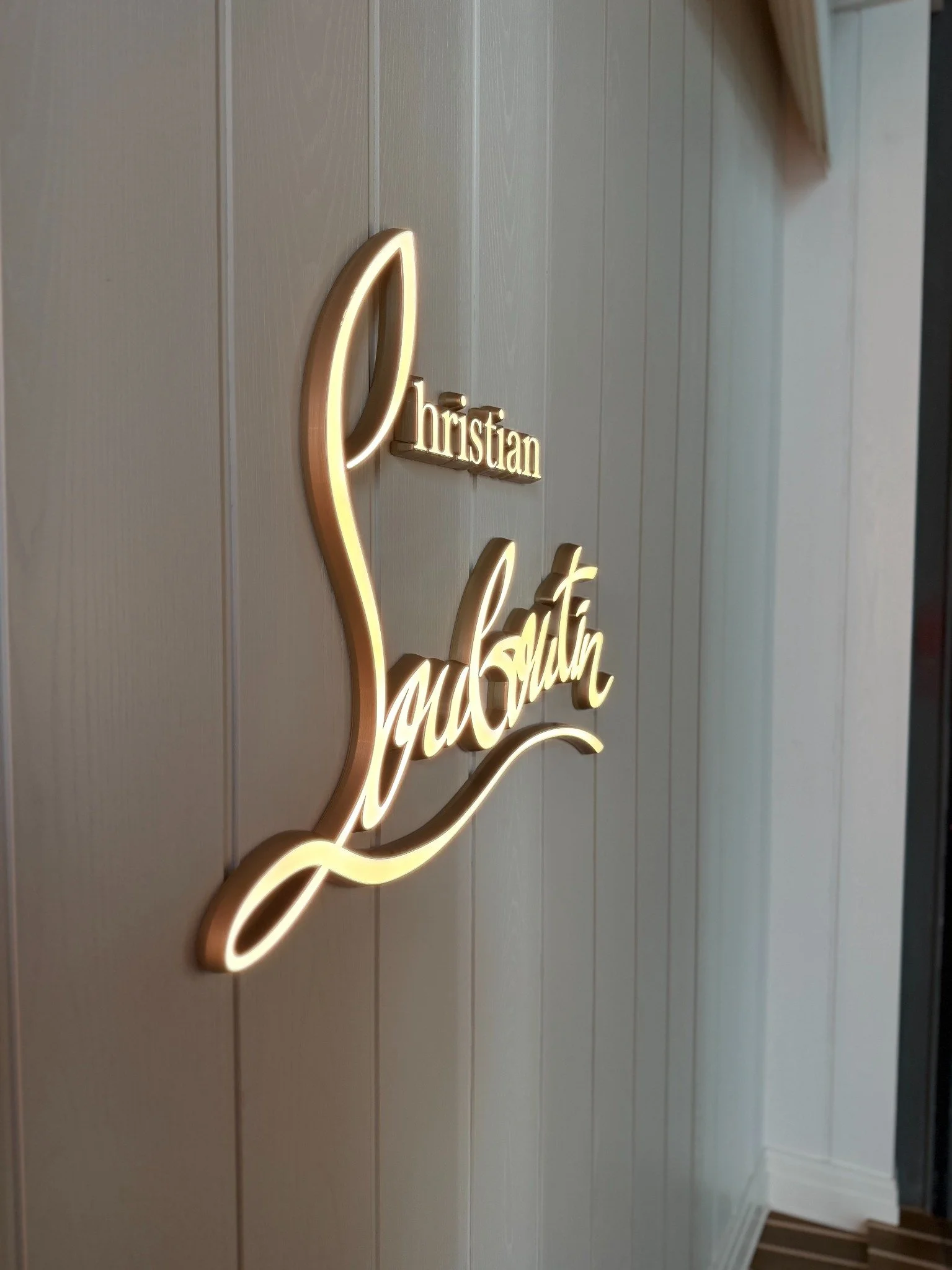 Decorative sign on wall reading 'Christian Life' with a stylized heart outline, illuminated in warm light.