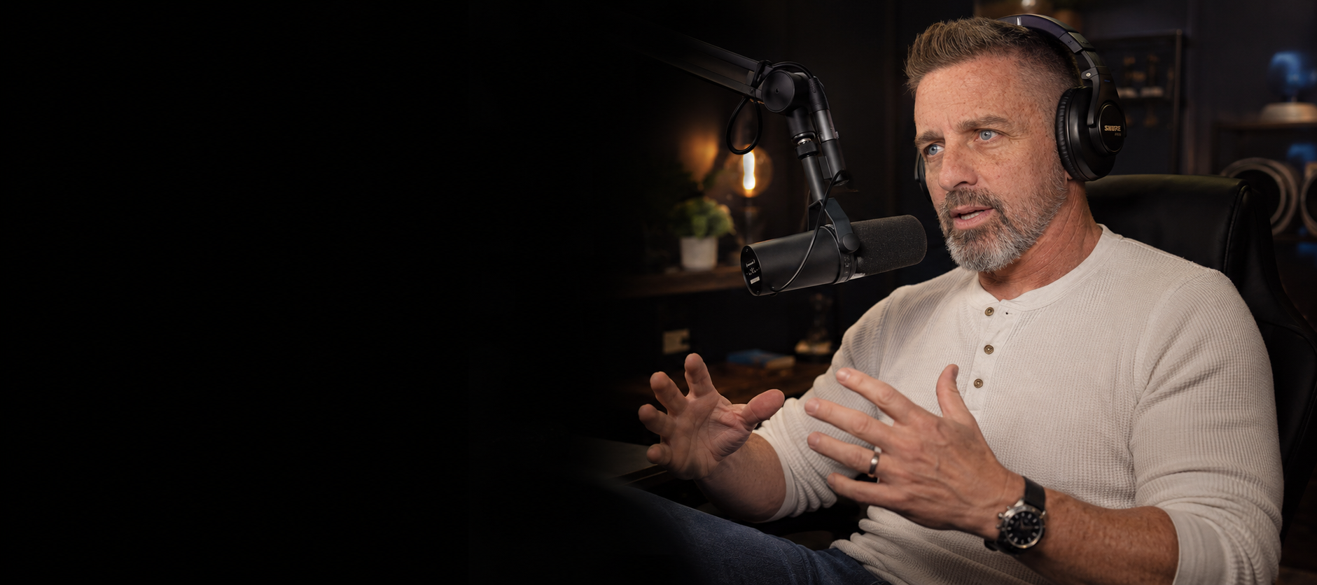 Craig Sawyer speaking into a podcast microphone in a dark studio setting, representing his guest podcast availability, interview conversations, and personal storytelling.
