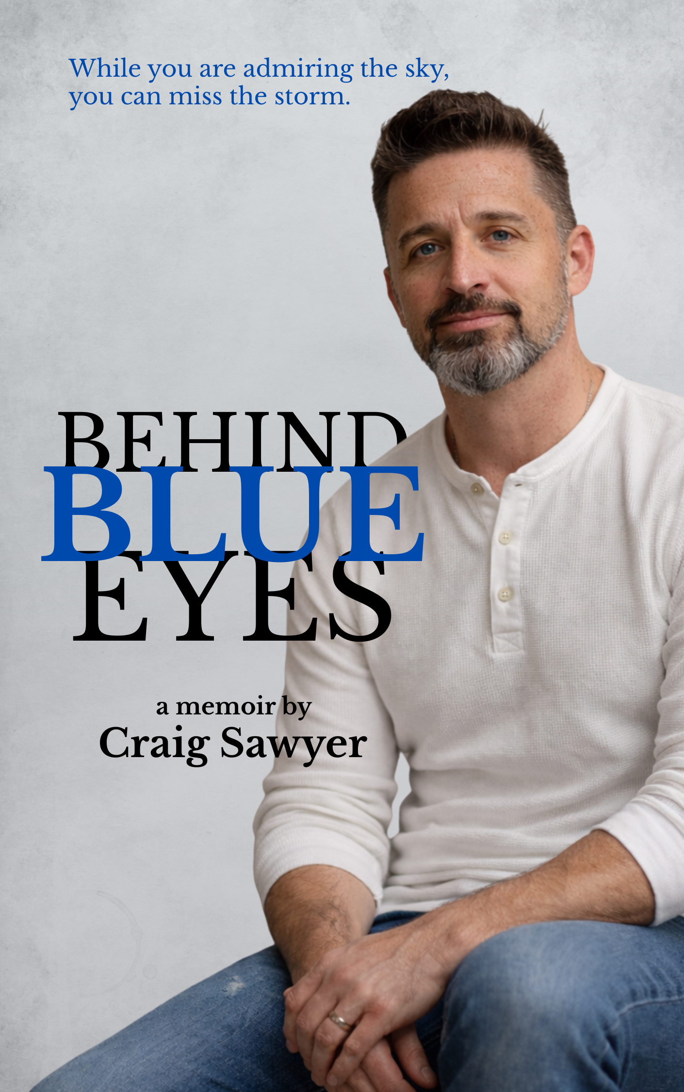Book cover for Behind Blue Eyes, a memoir by Craig Sawyer, featuring the author seated in a white shirt.