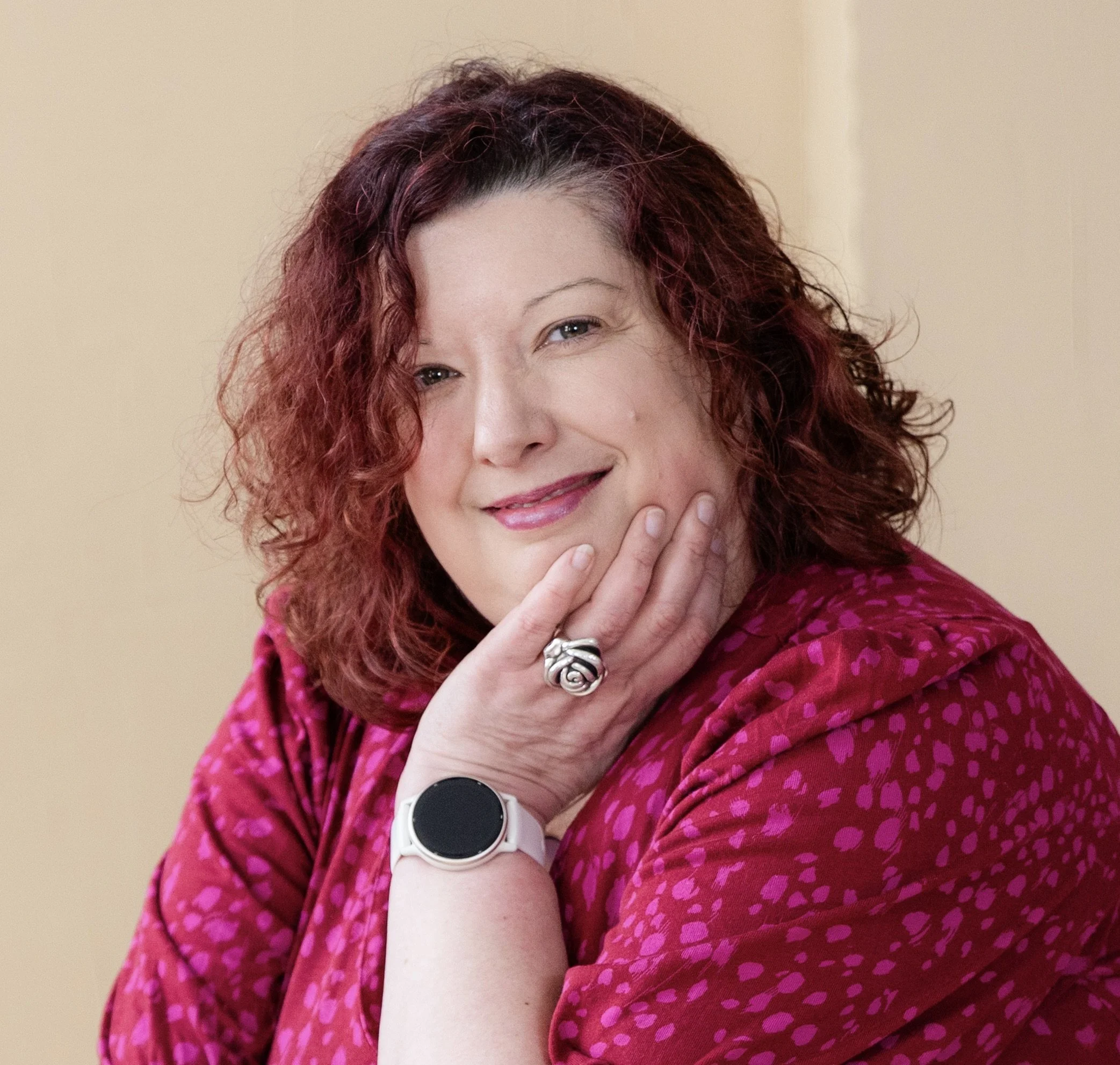 Photograph of Beth Roberts, trauma informed counsellor in Oxford UK. Beth is smiling and has hand on chin.