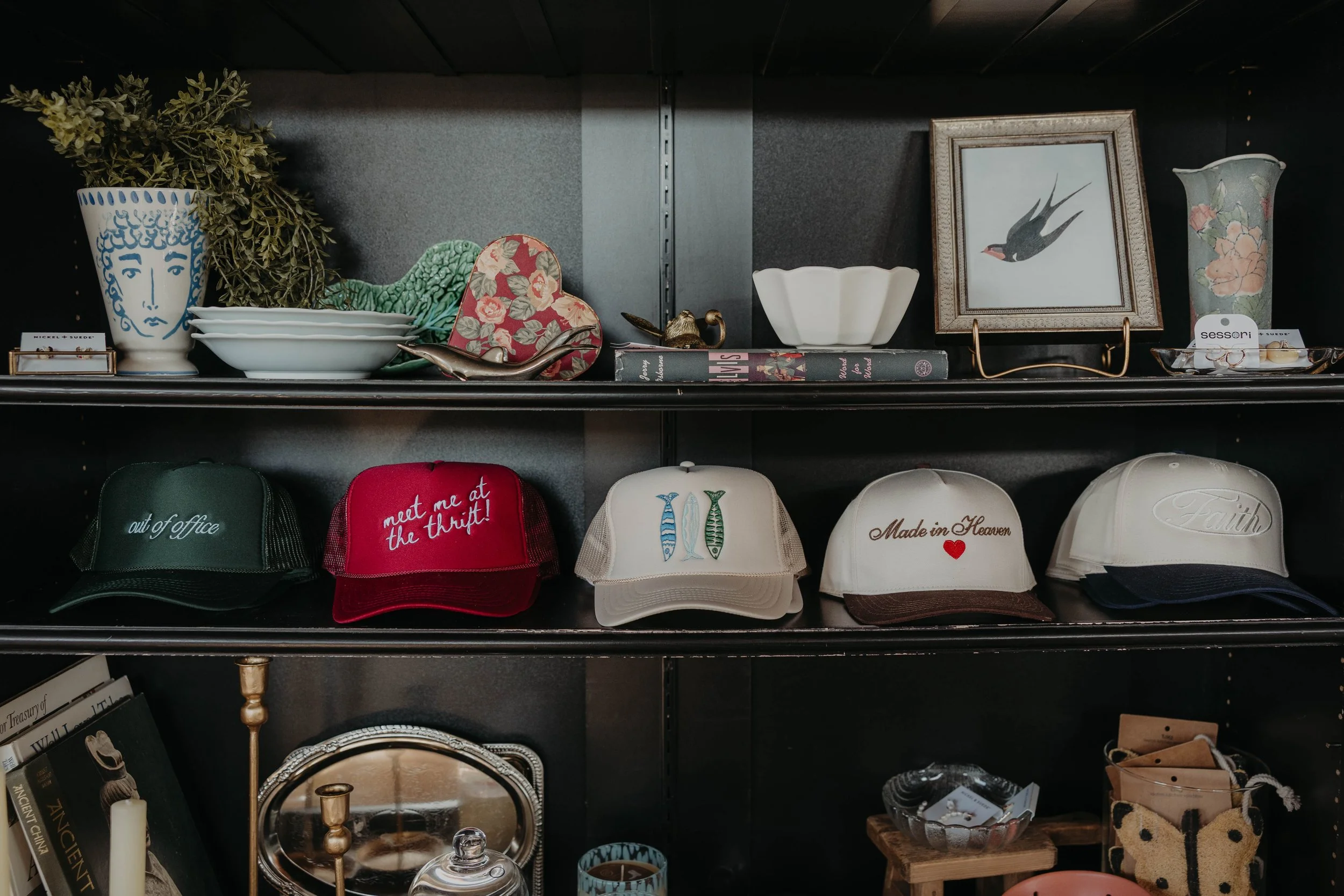 Display shelf with various decorative items including bowls, framed art, and hats.