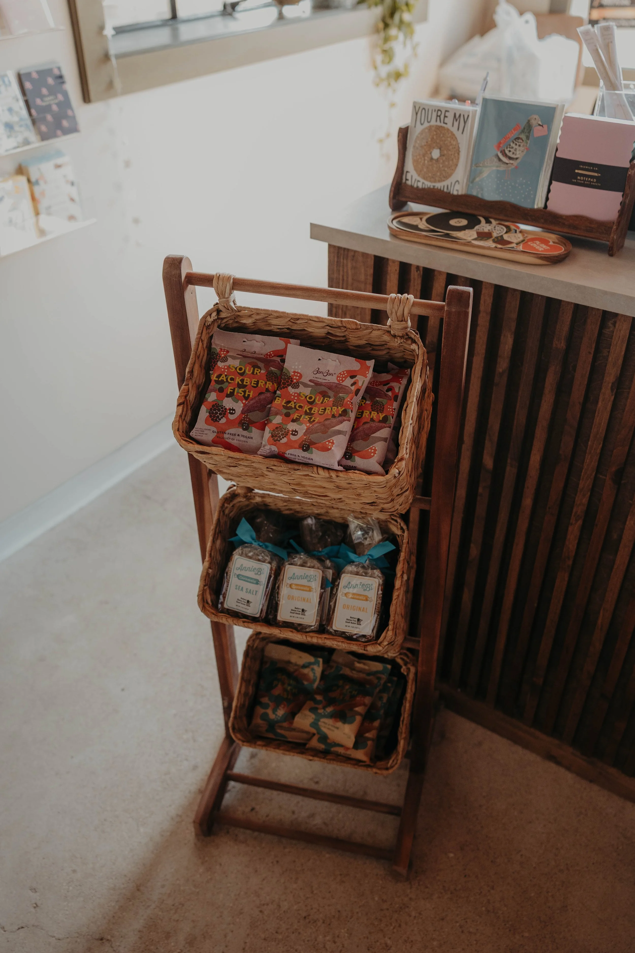 Wooden display stand holding several packages of food products, including candy.