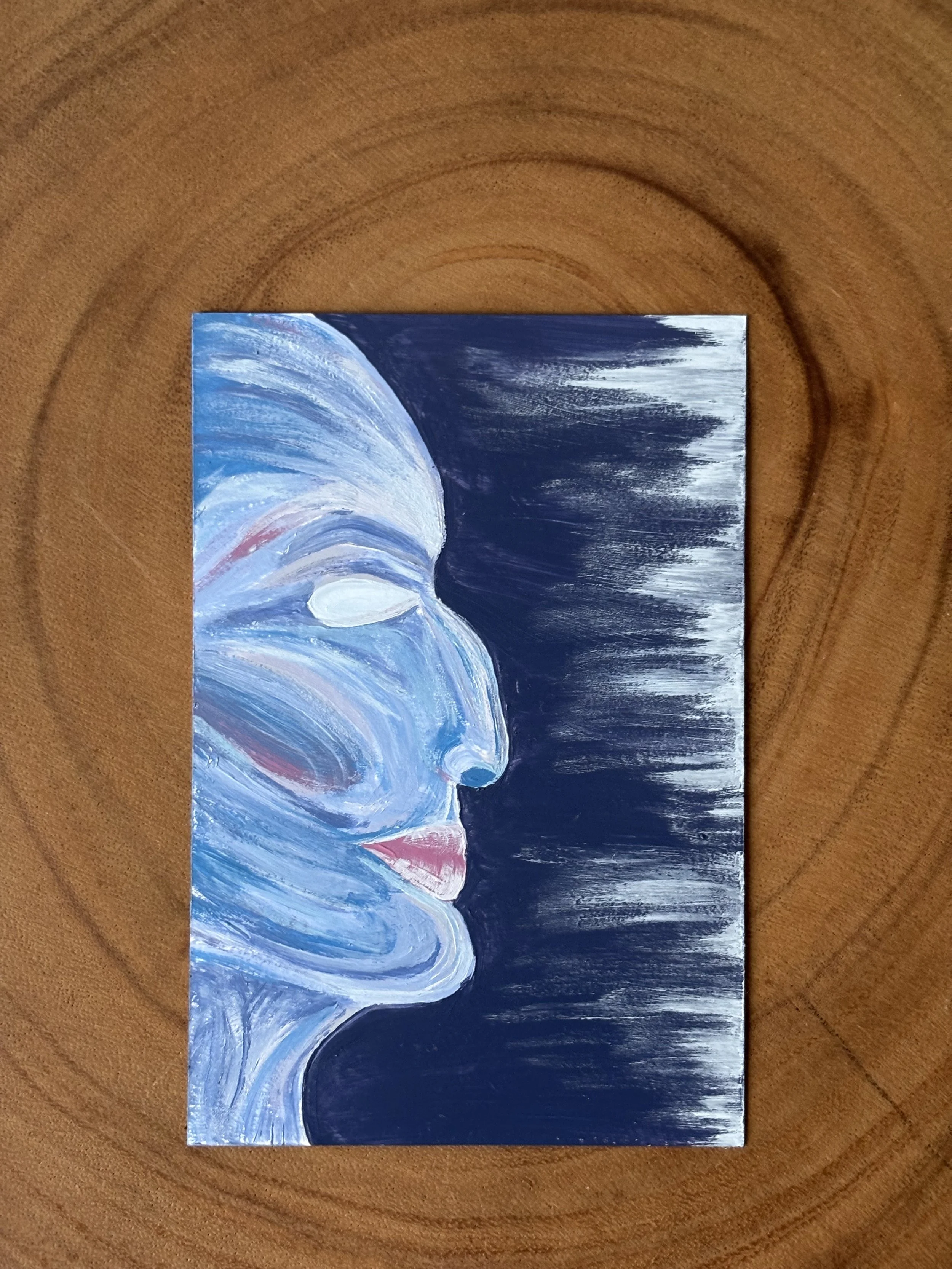 Abstract painting of a human face in profile, with closed eyes and lips, using blue, white, and pink tones, on a dark background. Alien-esque.