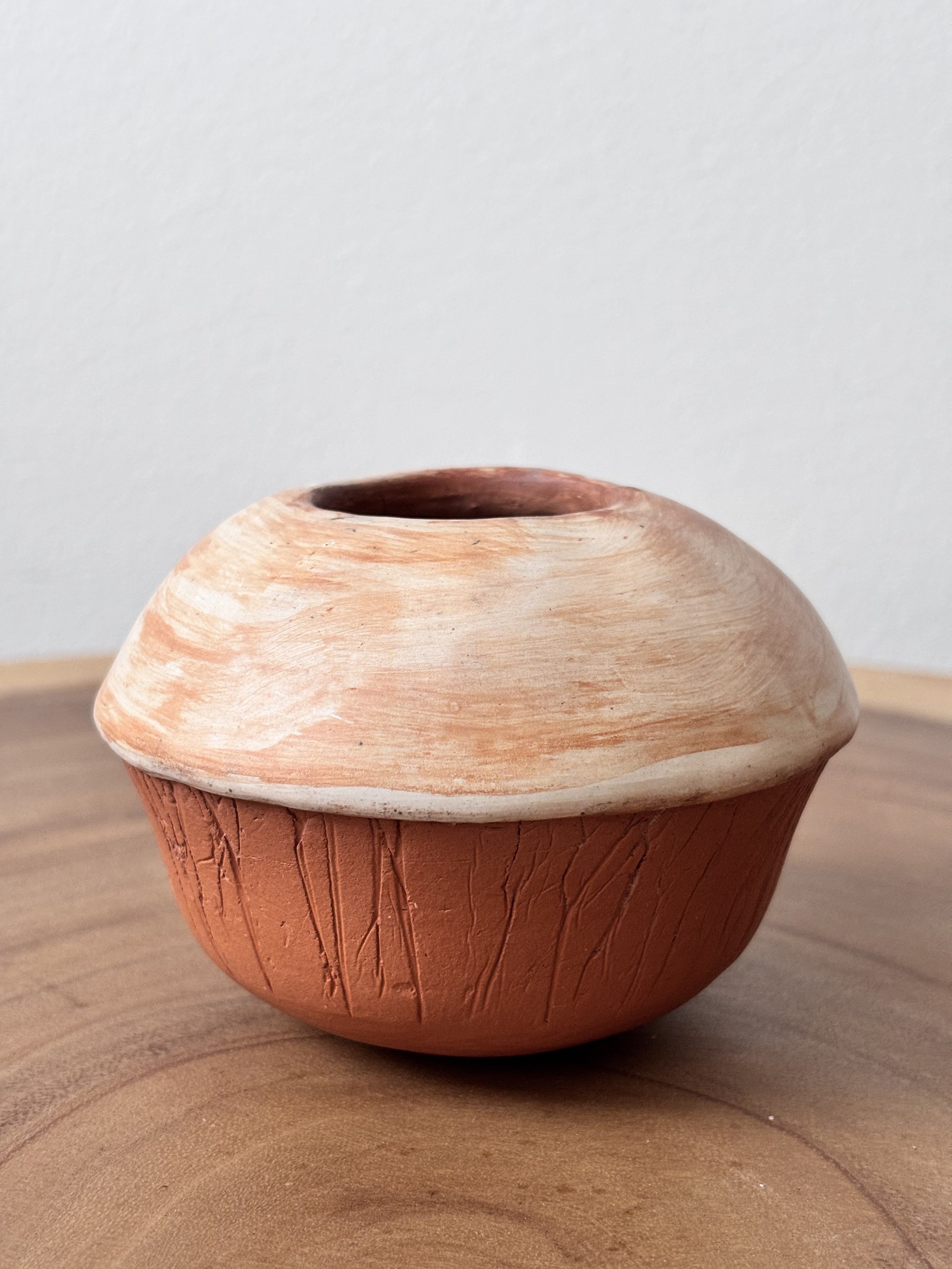 A small ceramic bowl with a rounded shape, textured exterior. Made from self-harvested and processed wild clay.
