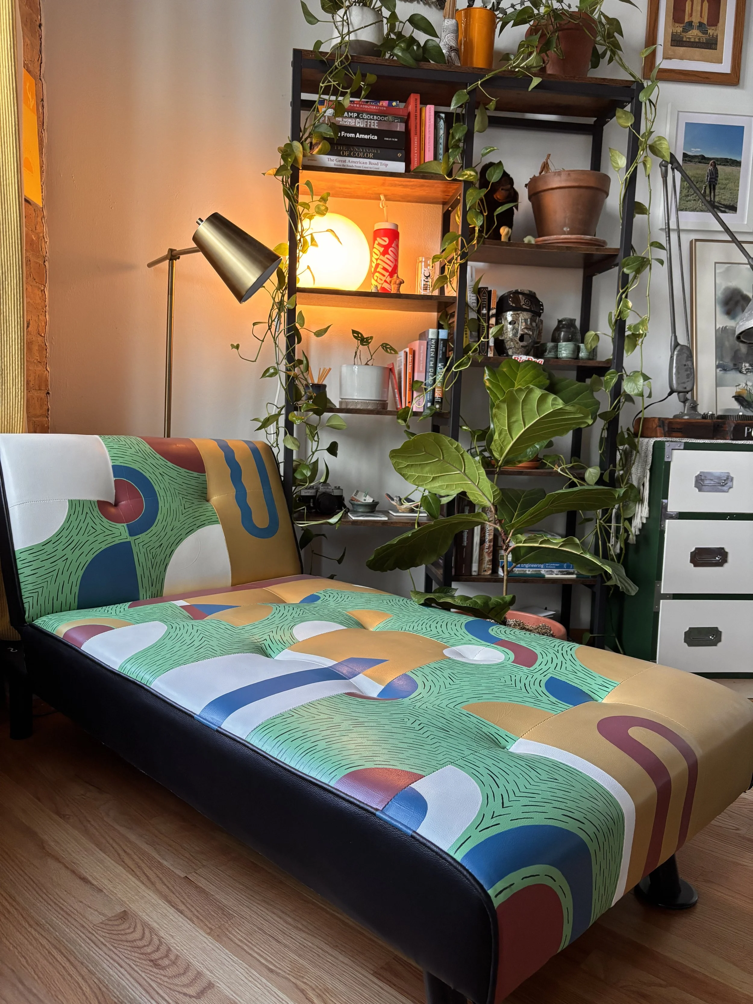 Colorfully painted leather on a modern lounge chair with a patchwork design of various colors and shapes. Custom furniture painting. 