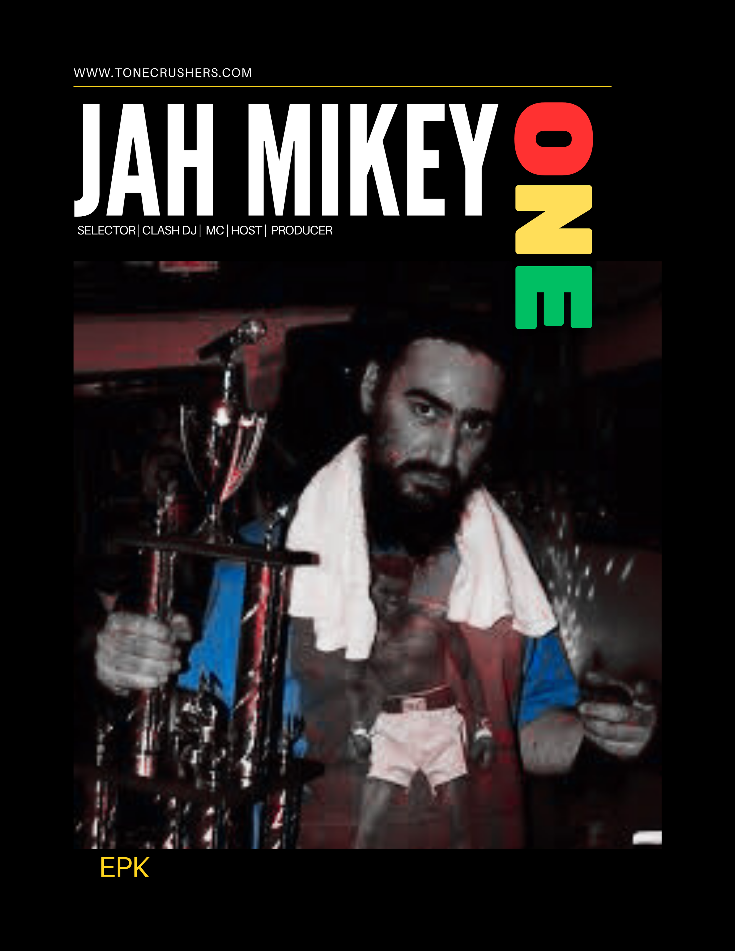 A man with a beard holding a trophy in one hand and a thumbs-up with the other, with a towel around his neck, in a dimly lit setting. The image has a black border with colorful text at the top and bottom, promoting an event or person named Jah Mikey.