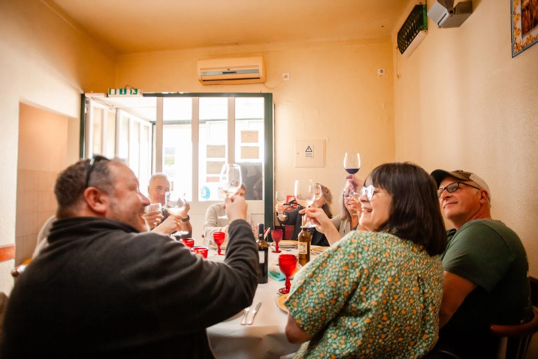 group of people at a table raising glasses up