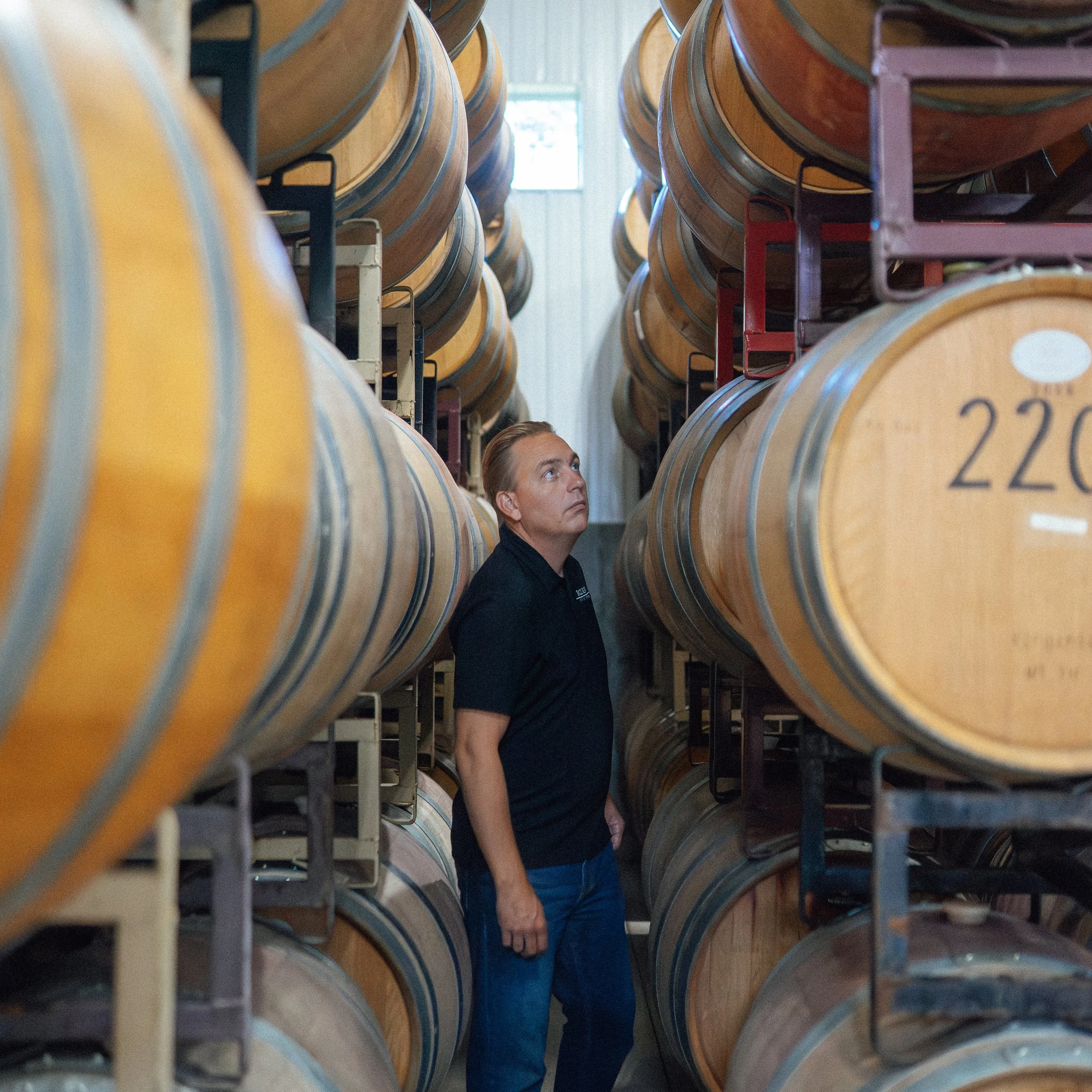 fox run vineyards winemaker next to wine barrels