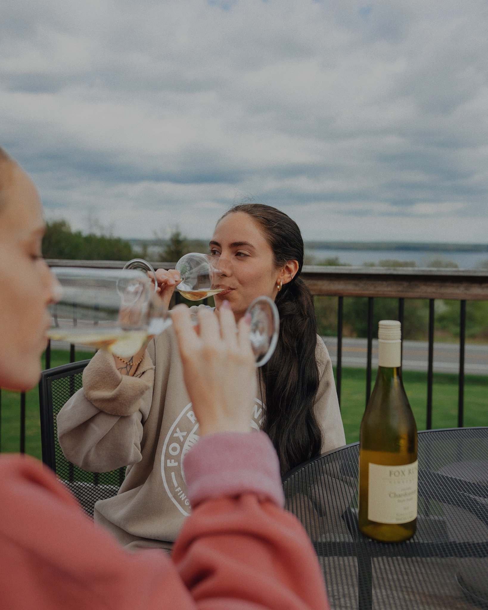 guest drinking glass of wine on patio deck
