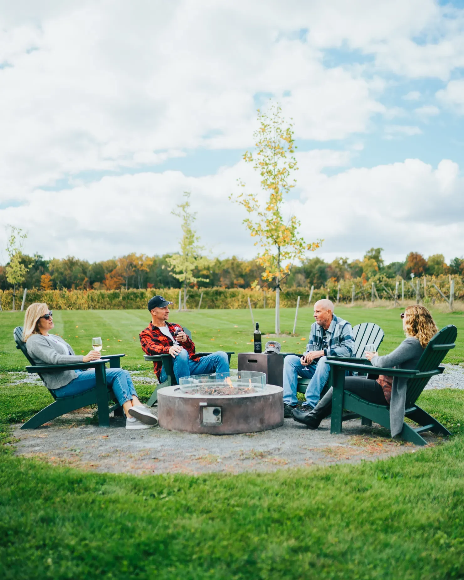 guests drinking wine around a fire pit outside the wine barn